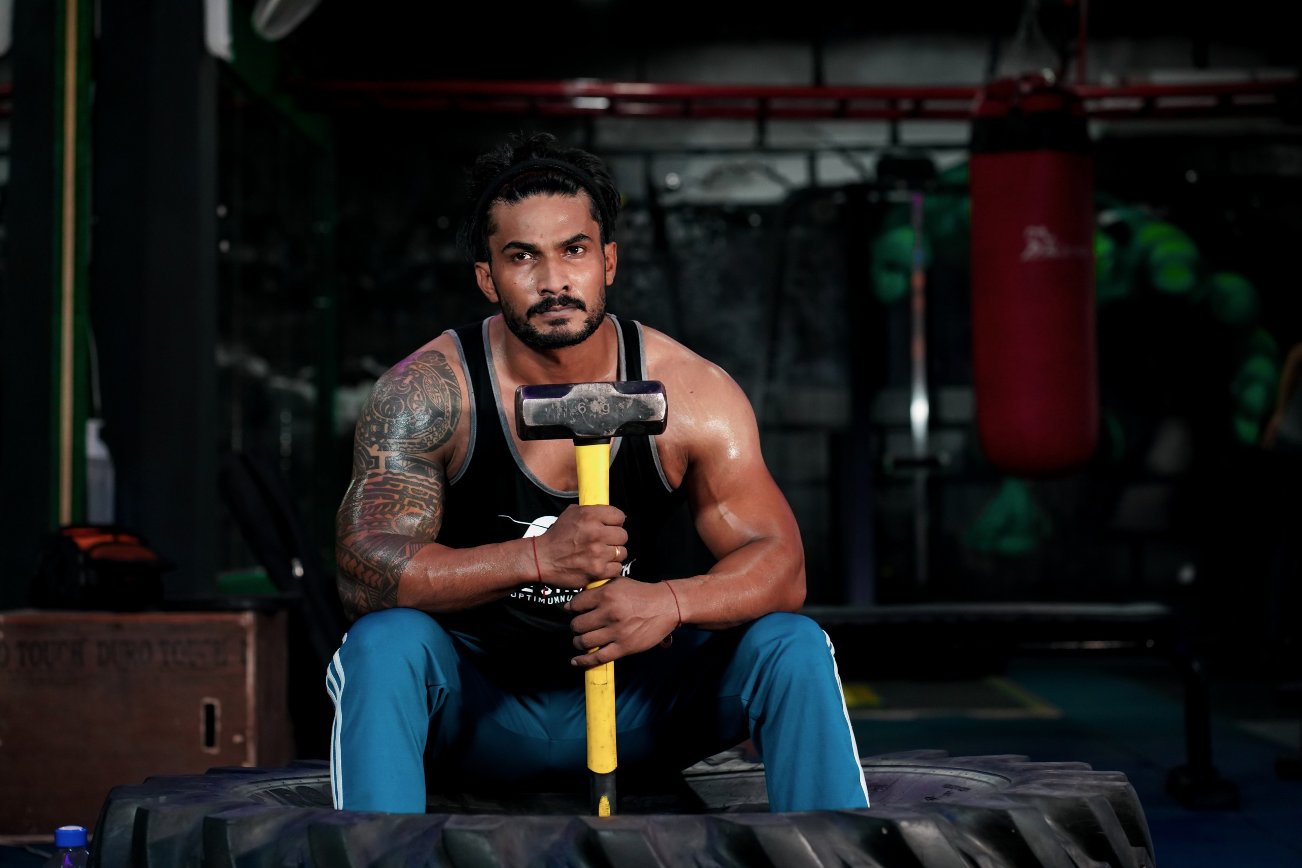 Bodybuilder holding a hammer at gym