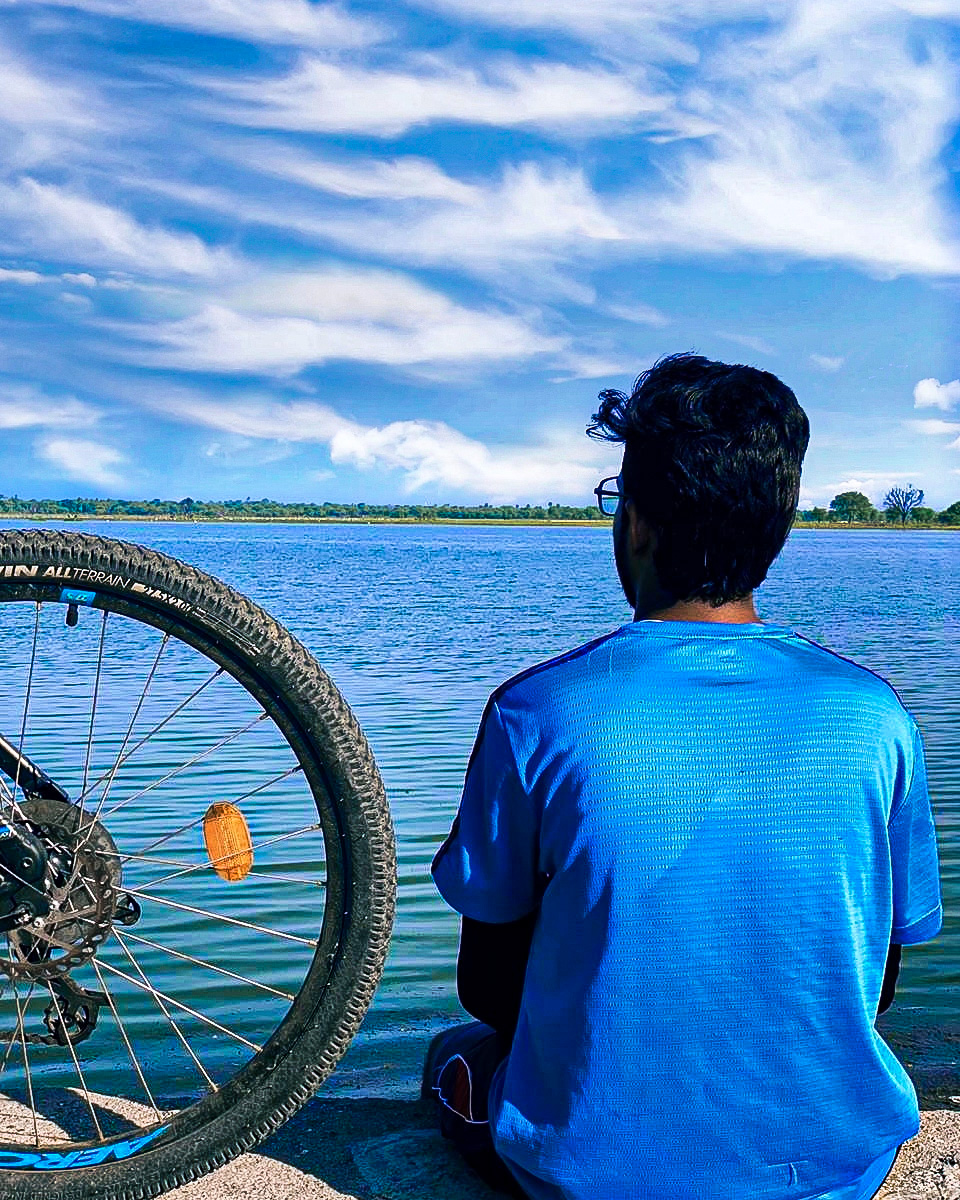 Boy Sitting in the Lakeside with his Bike