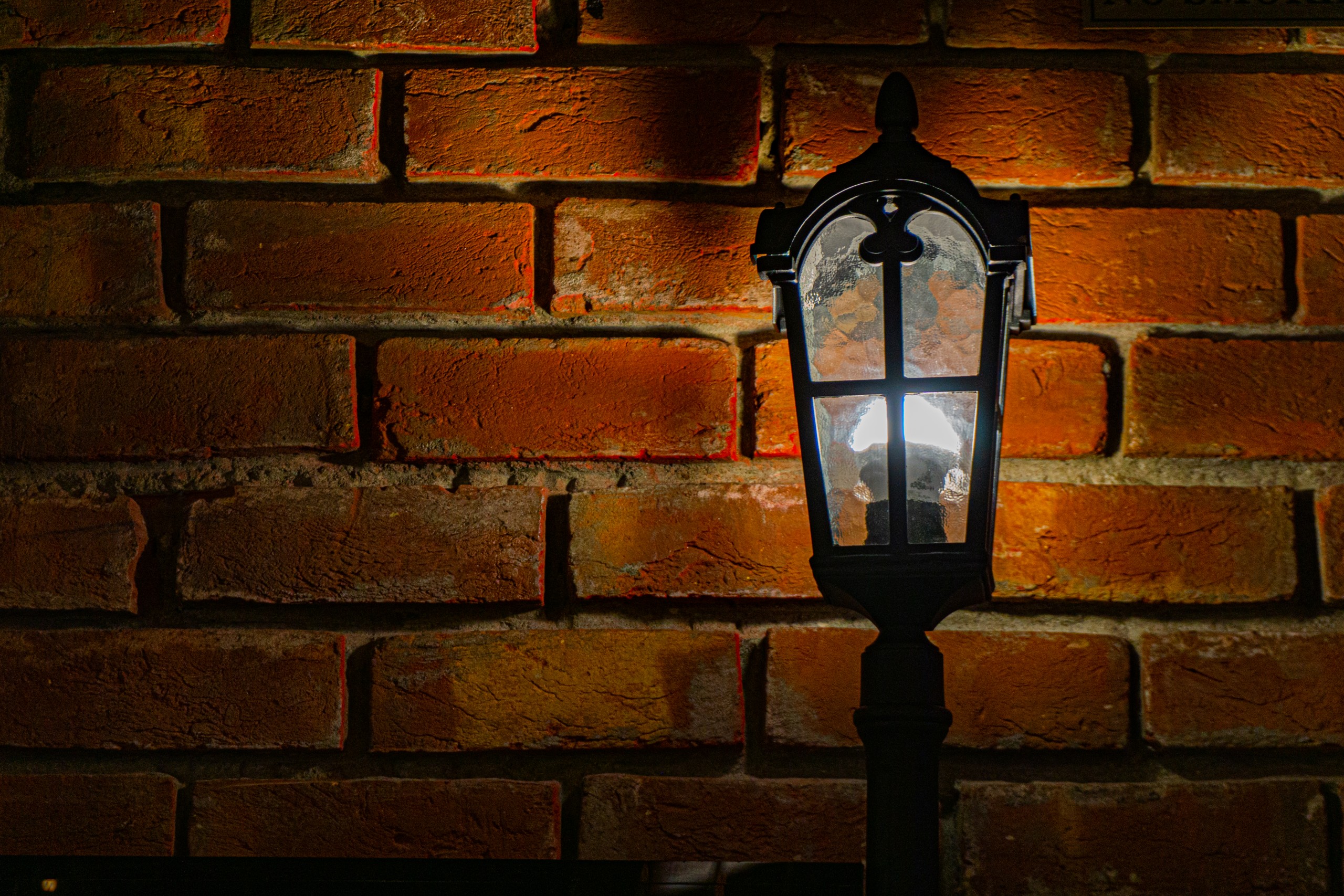 lamp in front of a brick wall