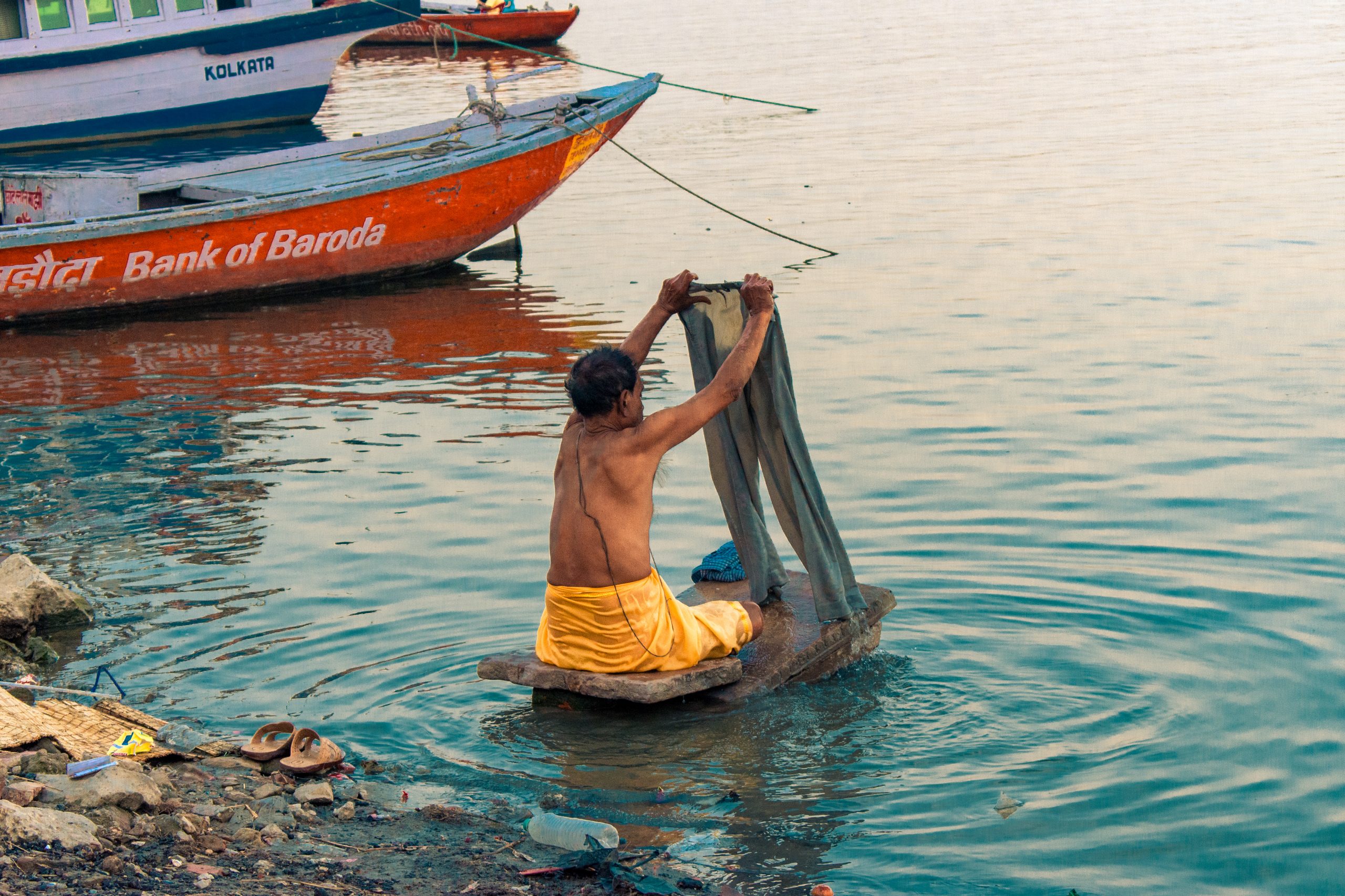 A man washing clothes in Ganga river.