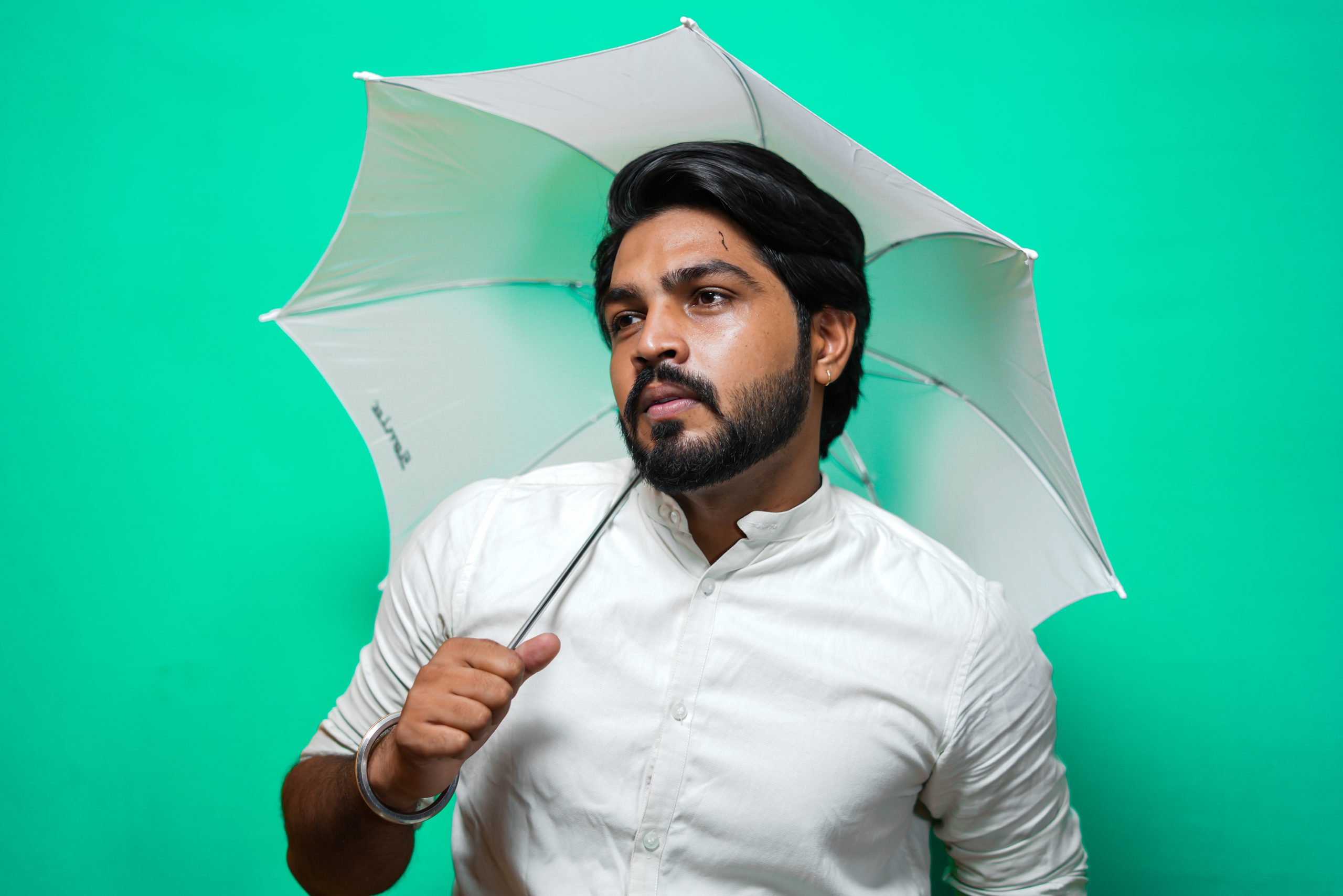 A serious man holding an umbrella