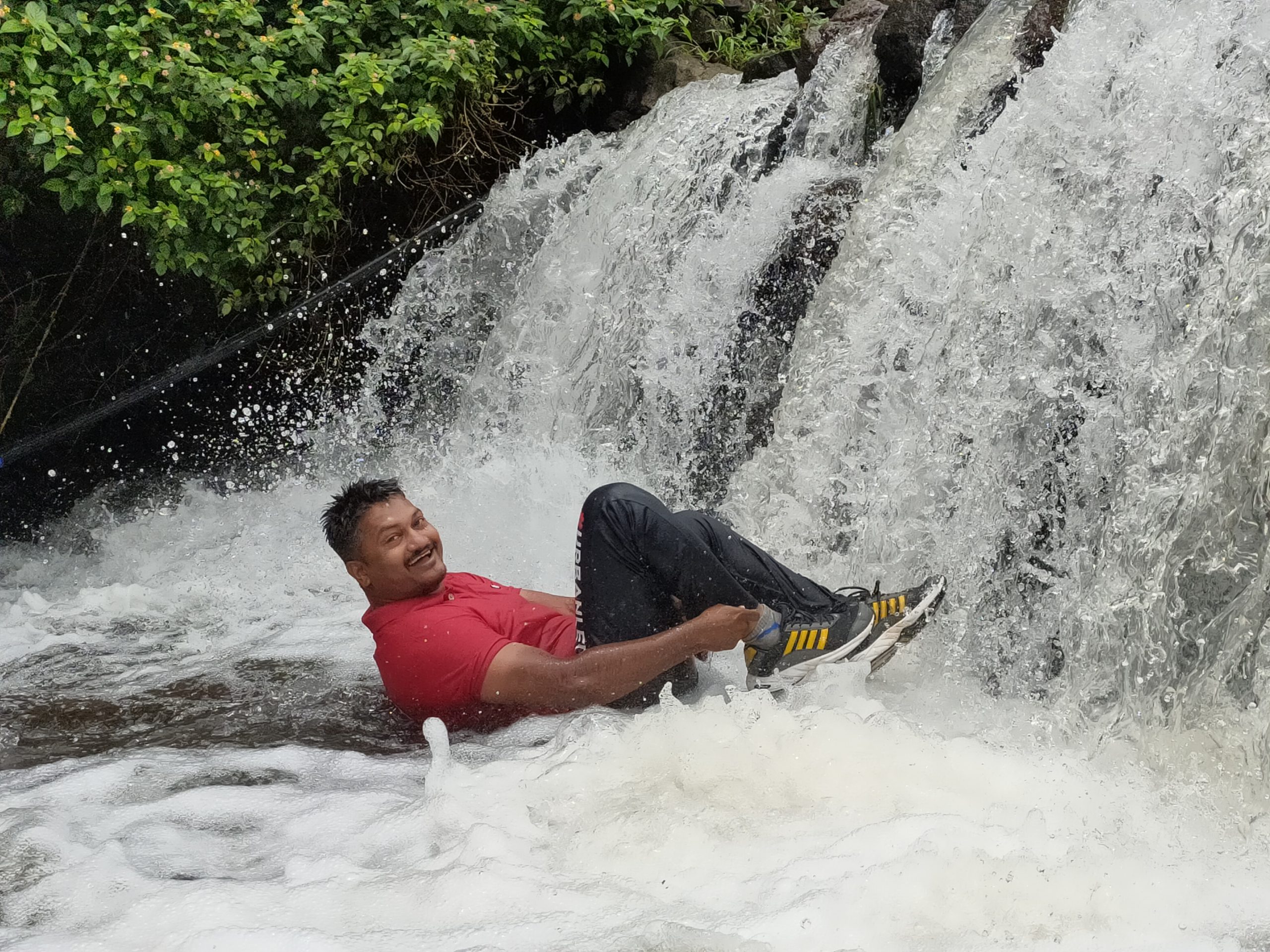 A man enjoying in a mini waterfall