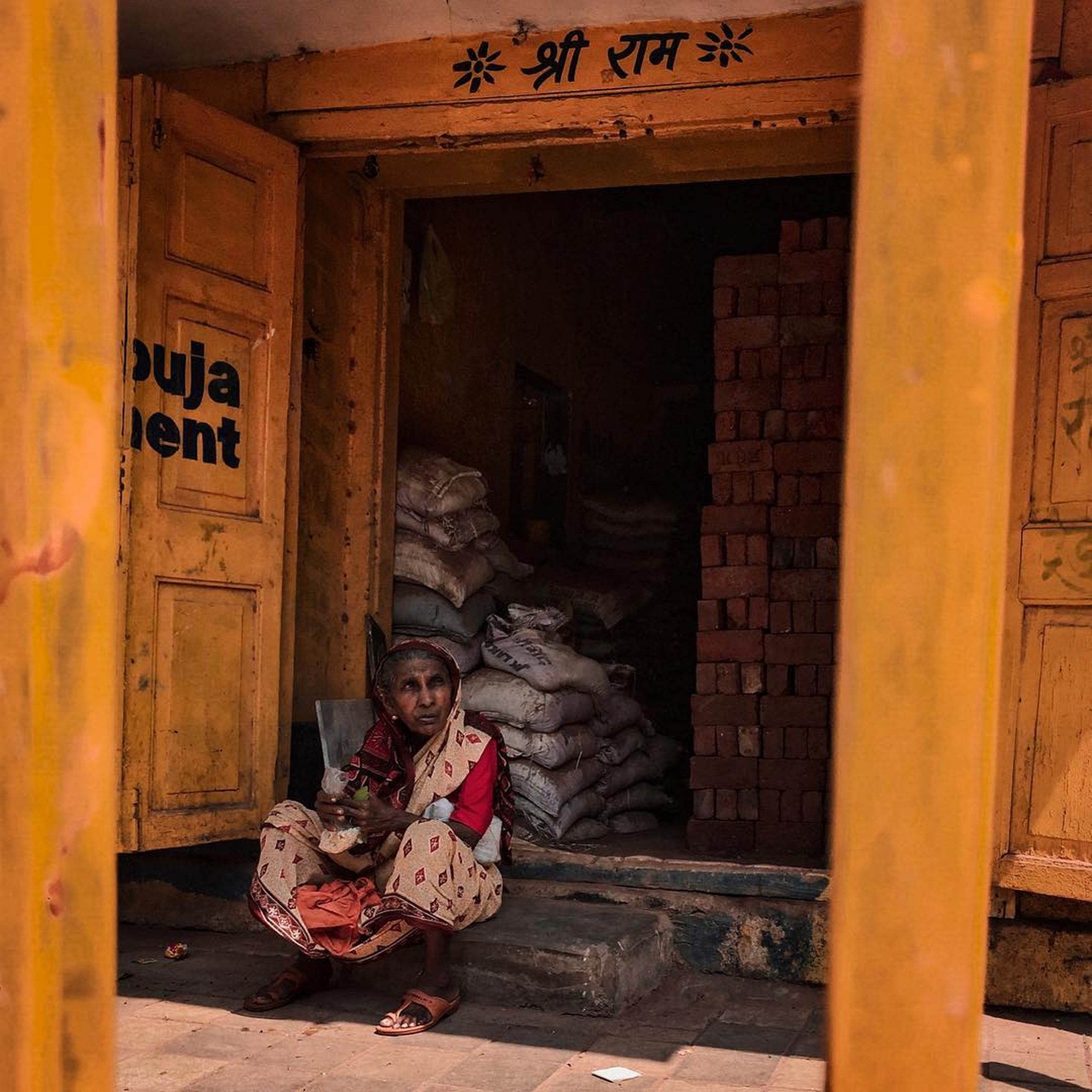 An old lady in bricks and cement shop