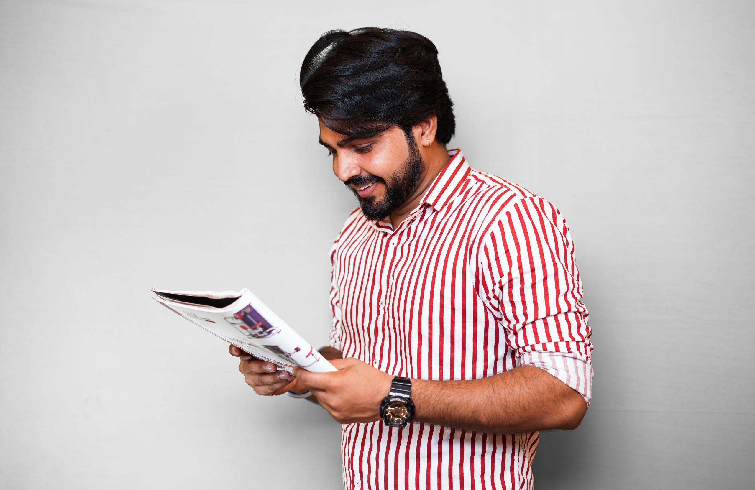 Boy Smiling and Reading Book on White Background