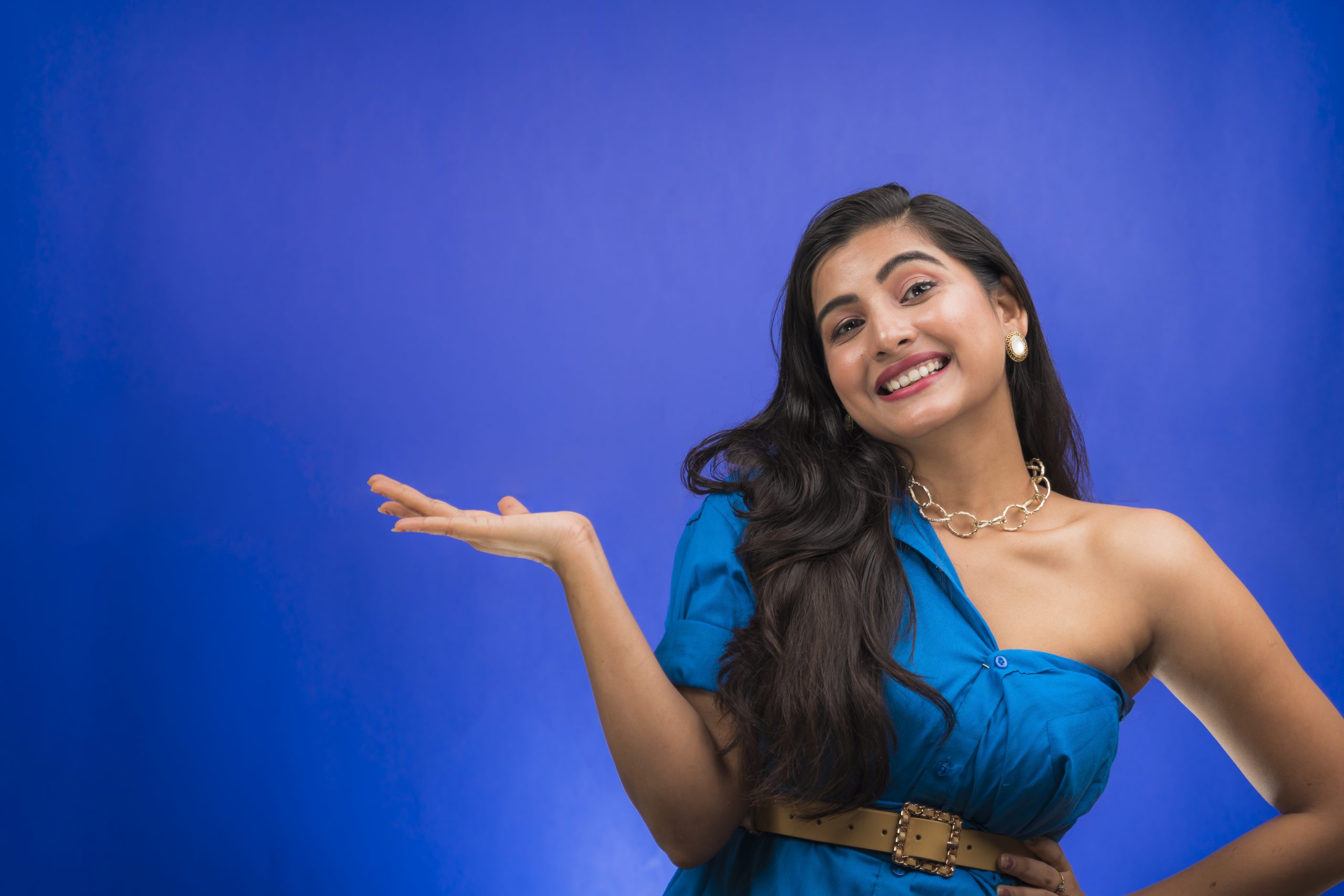 Happy Indian girl pointing hand sideways