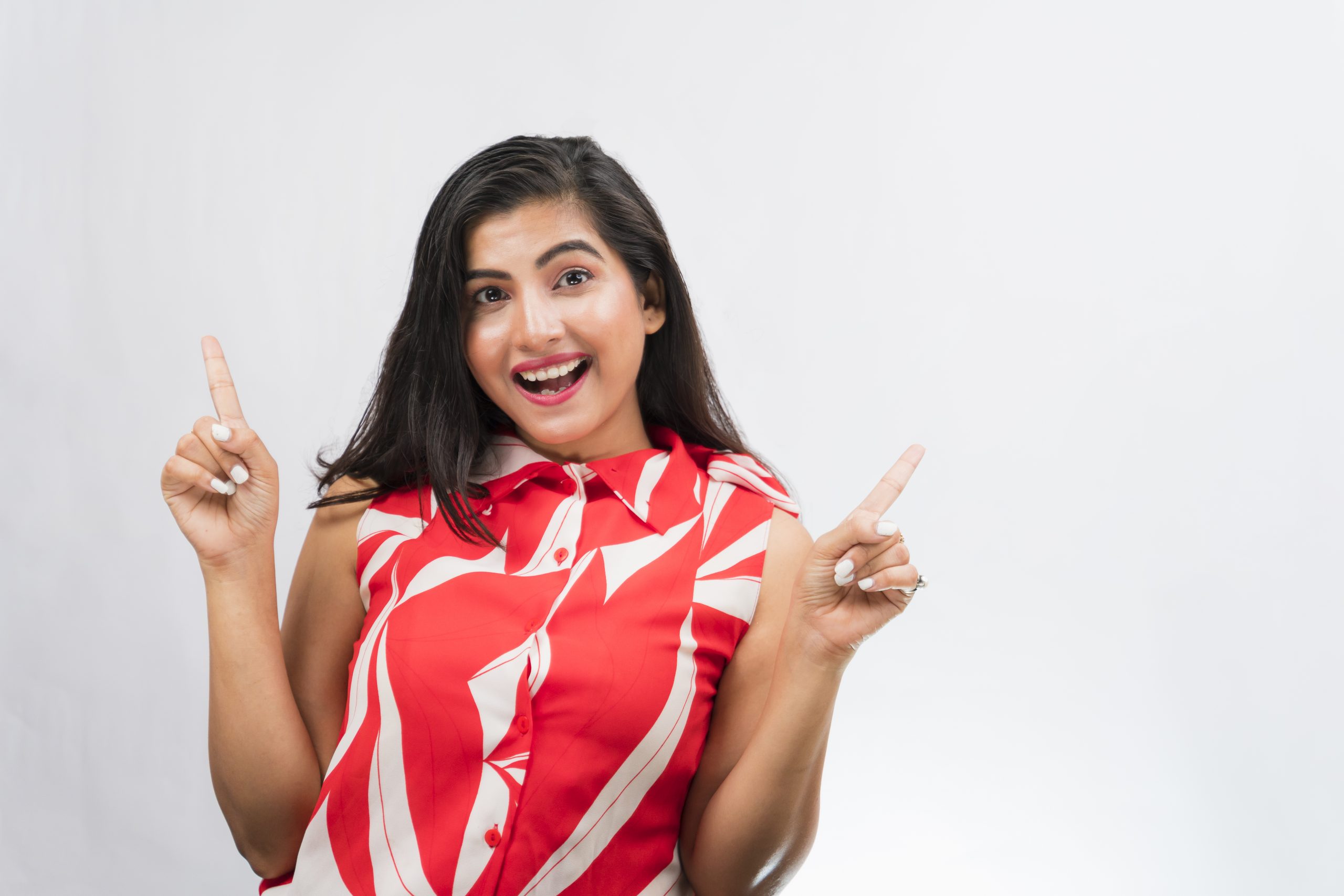 Happy Indian girl pointing upwards