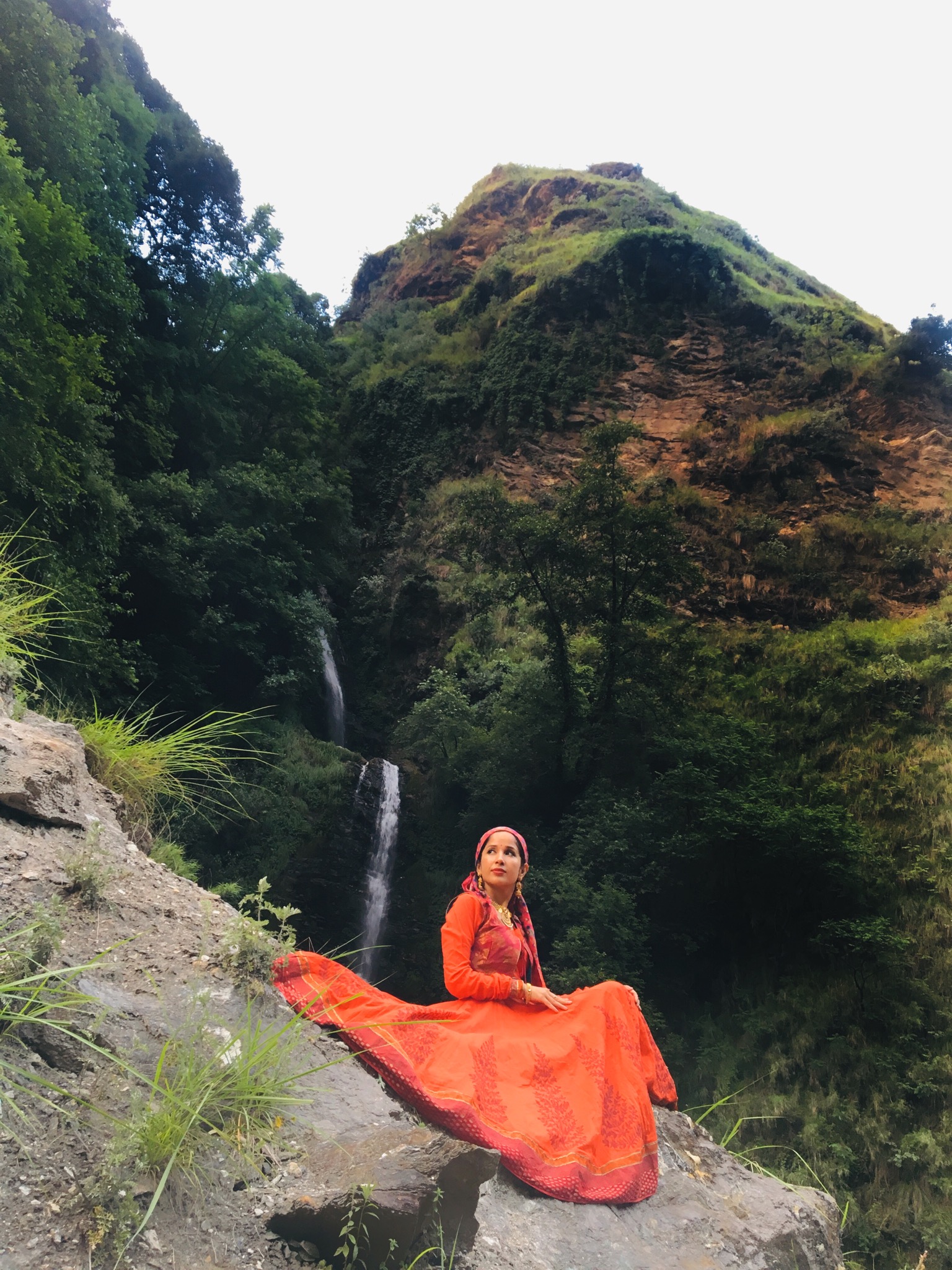 a beautiful woman sitting on a mountain