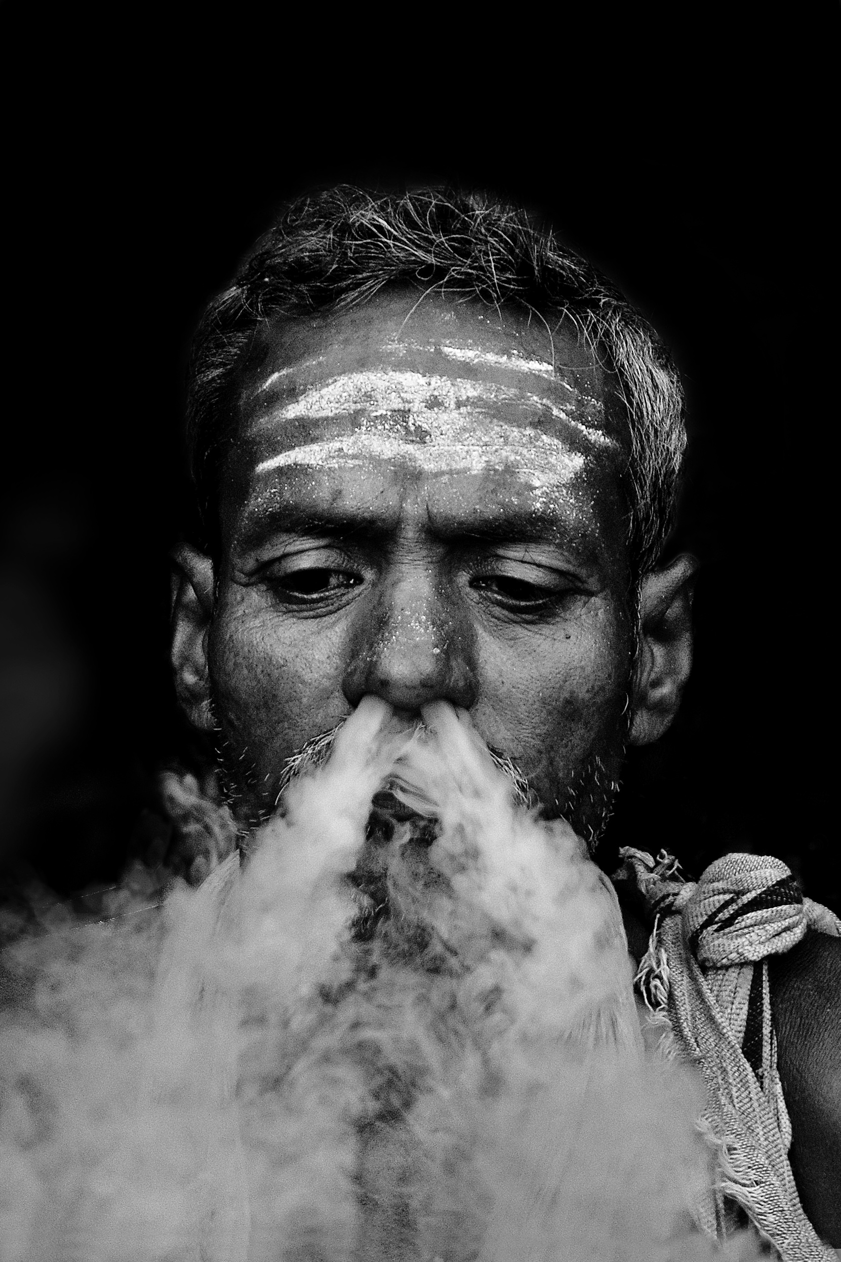 A sadhu smoking on the street.