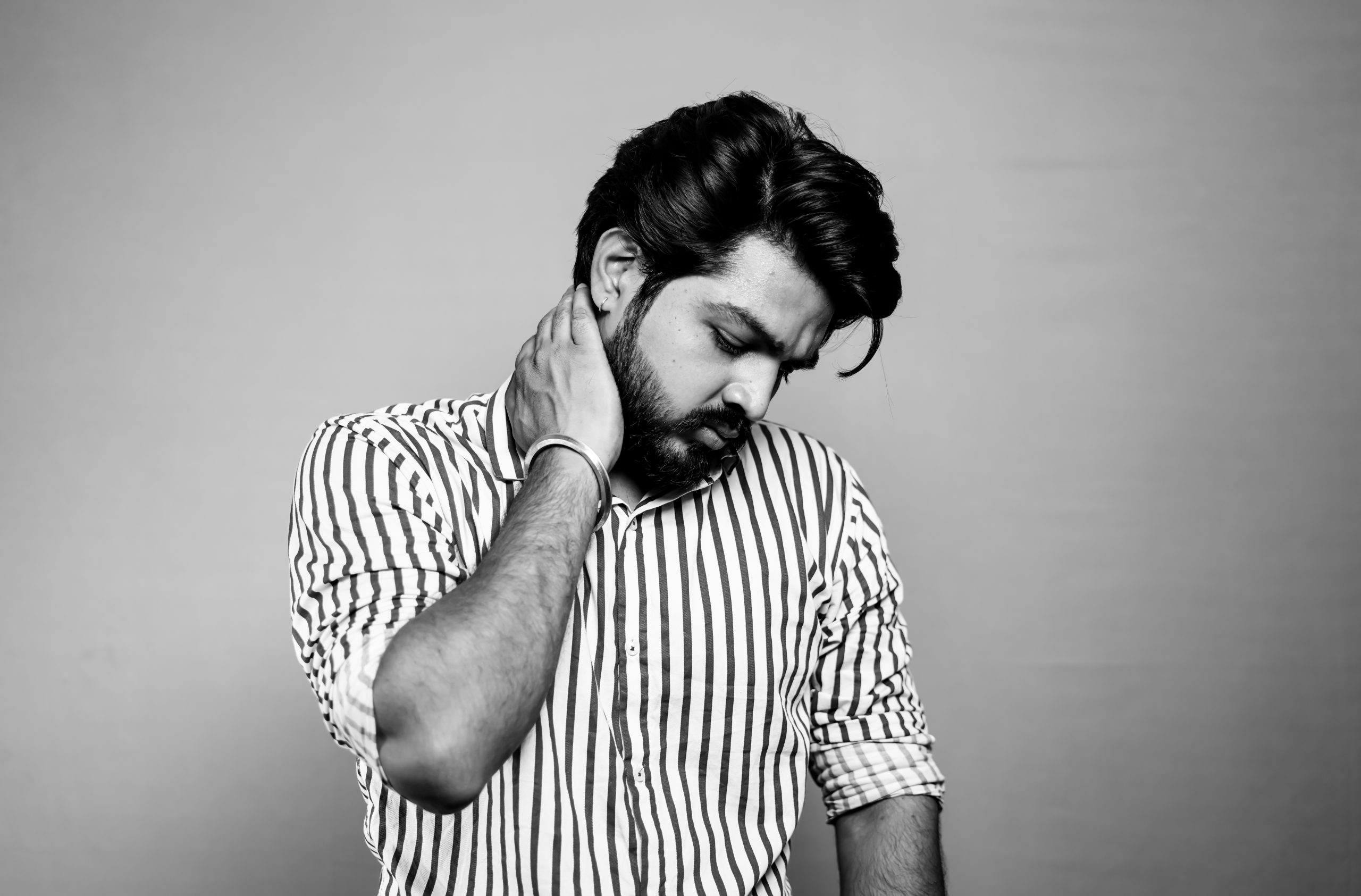 Indian male model in black and white with hand on his neck