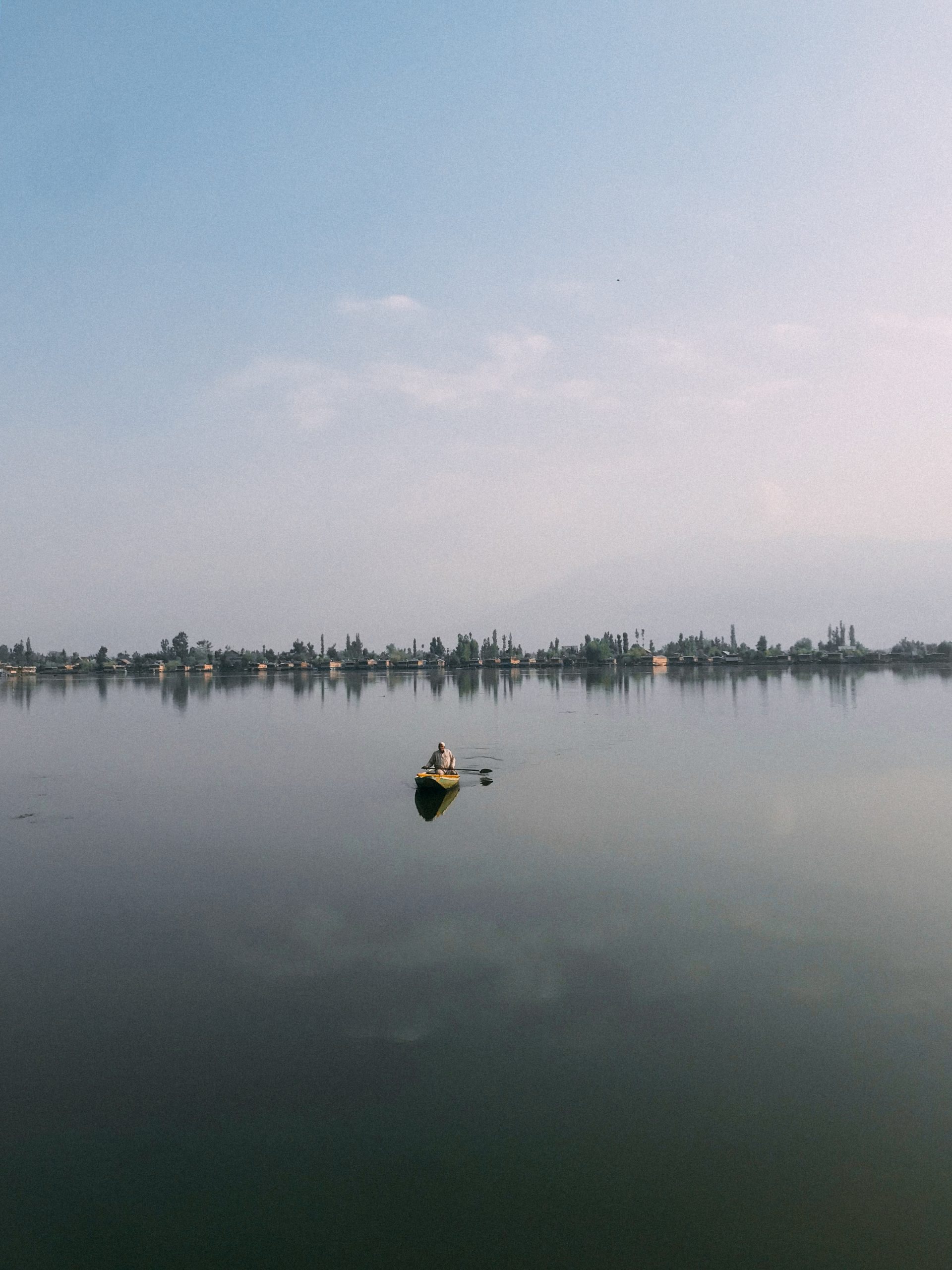 Man canoeing on large lake alone