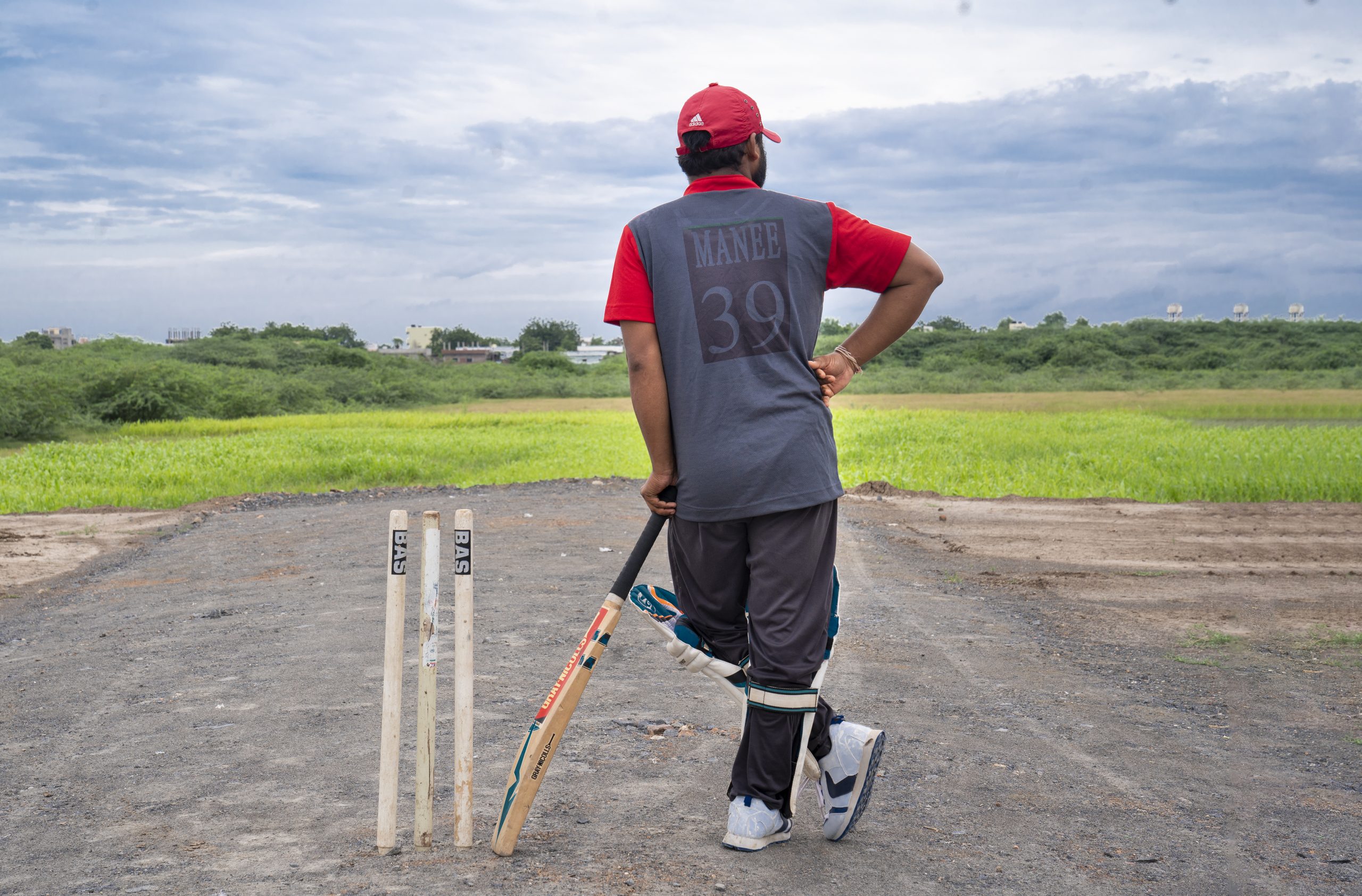 Man playing cricket in a rural area