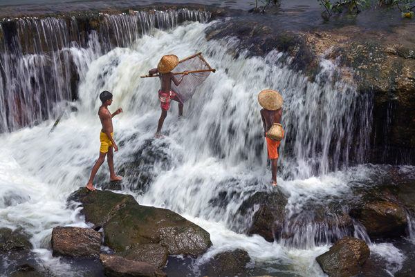 boys enjoying fishing in the waterfall