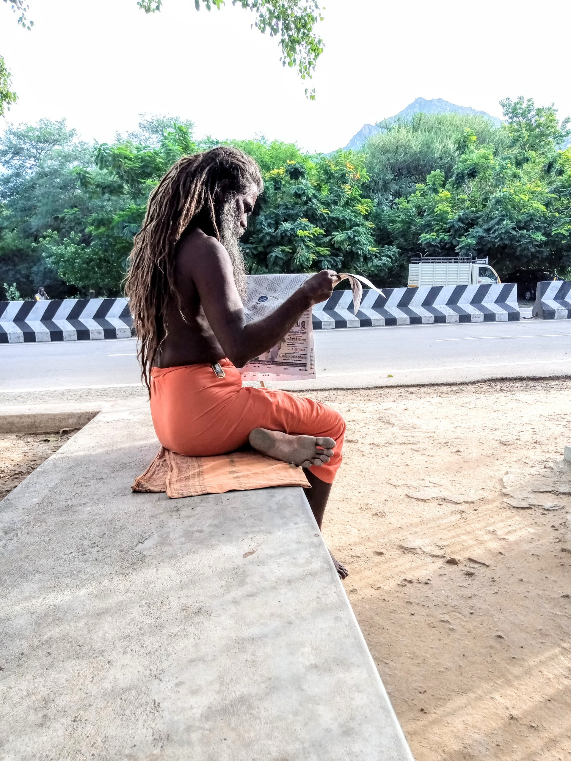 A sadhu reading newspaper.