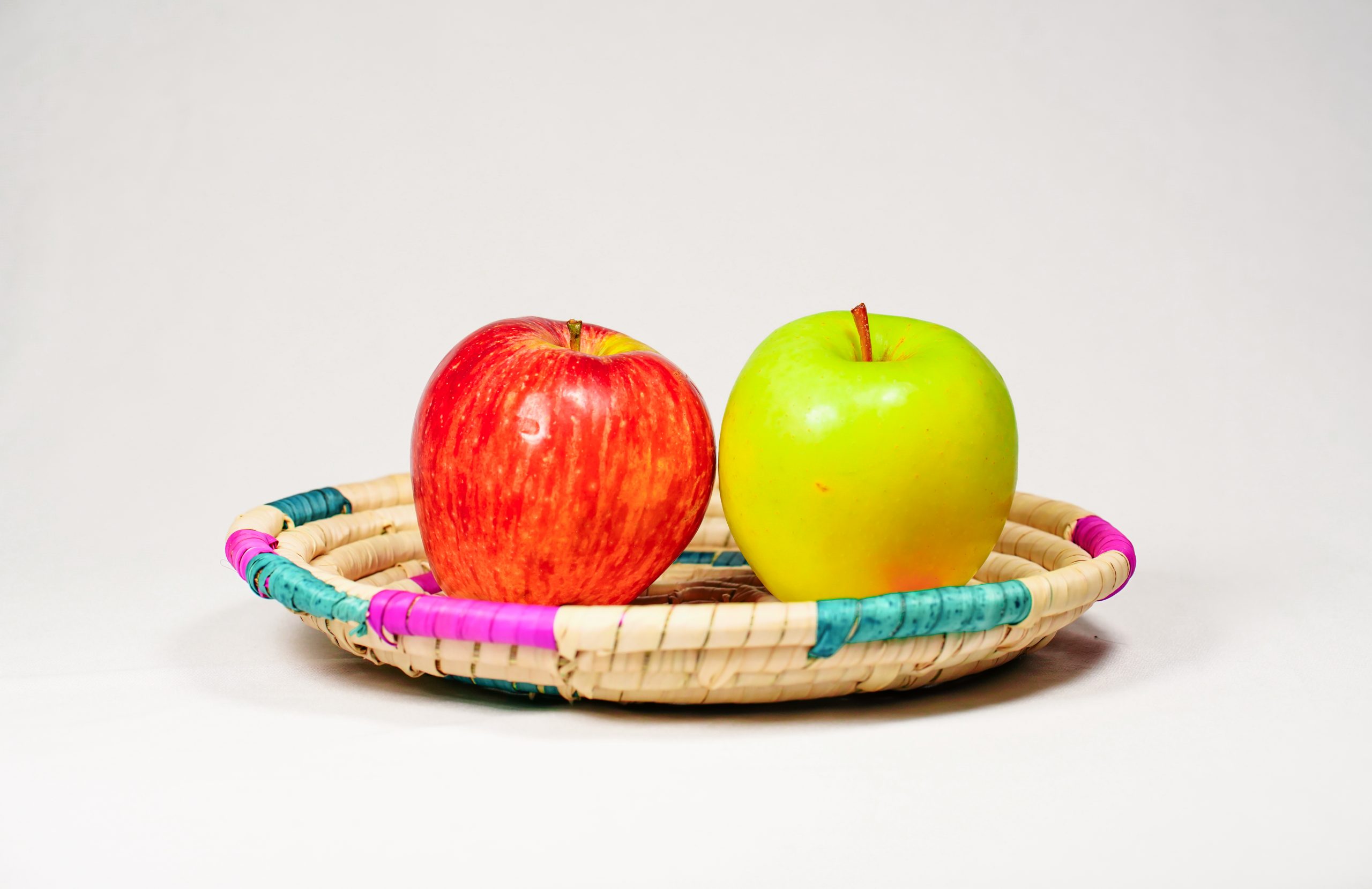 Red and golden apple in basket