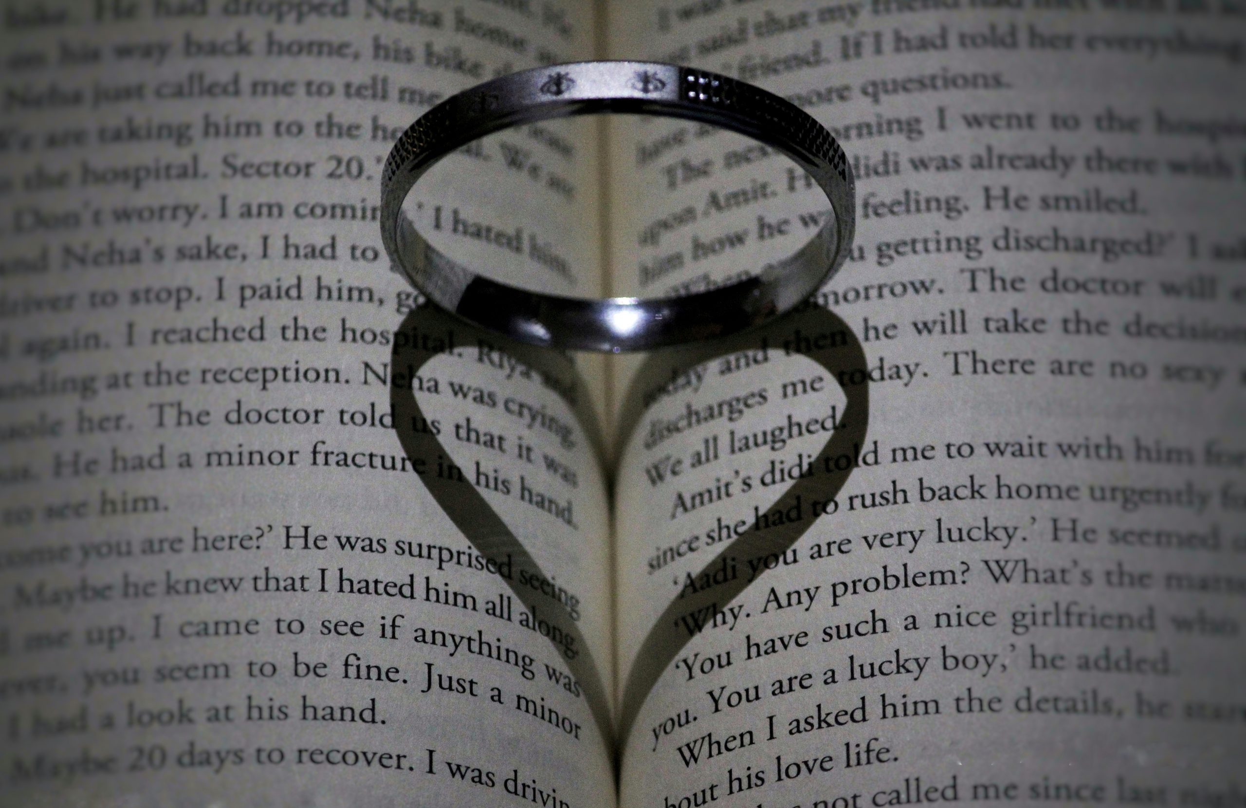Ring shadow making heart on a book