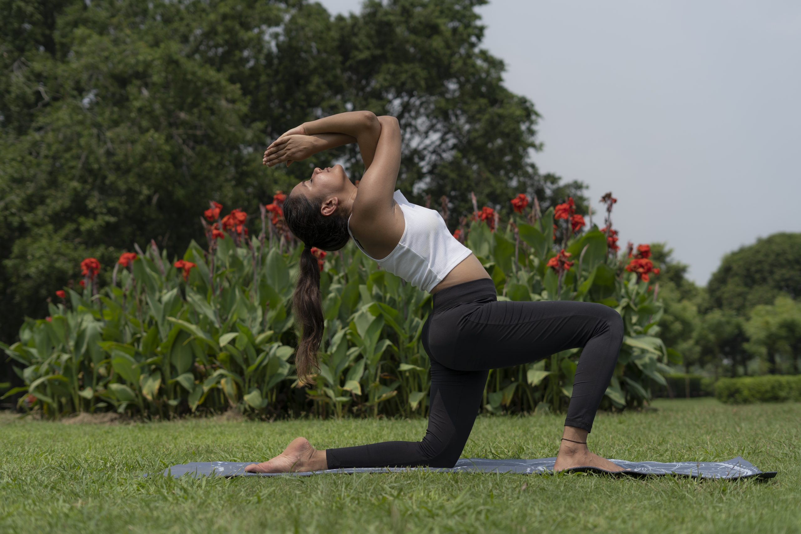 A girl doing yoga in a park.