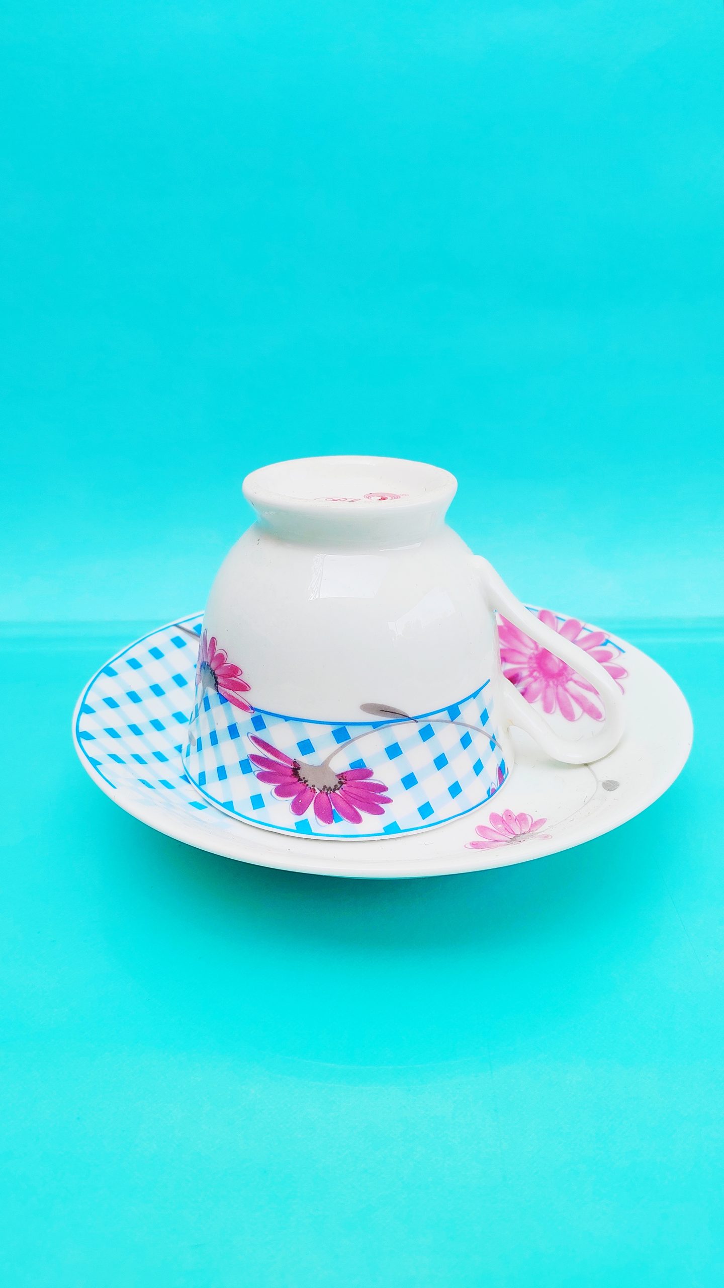 Teacup with plate on bright blue background