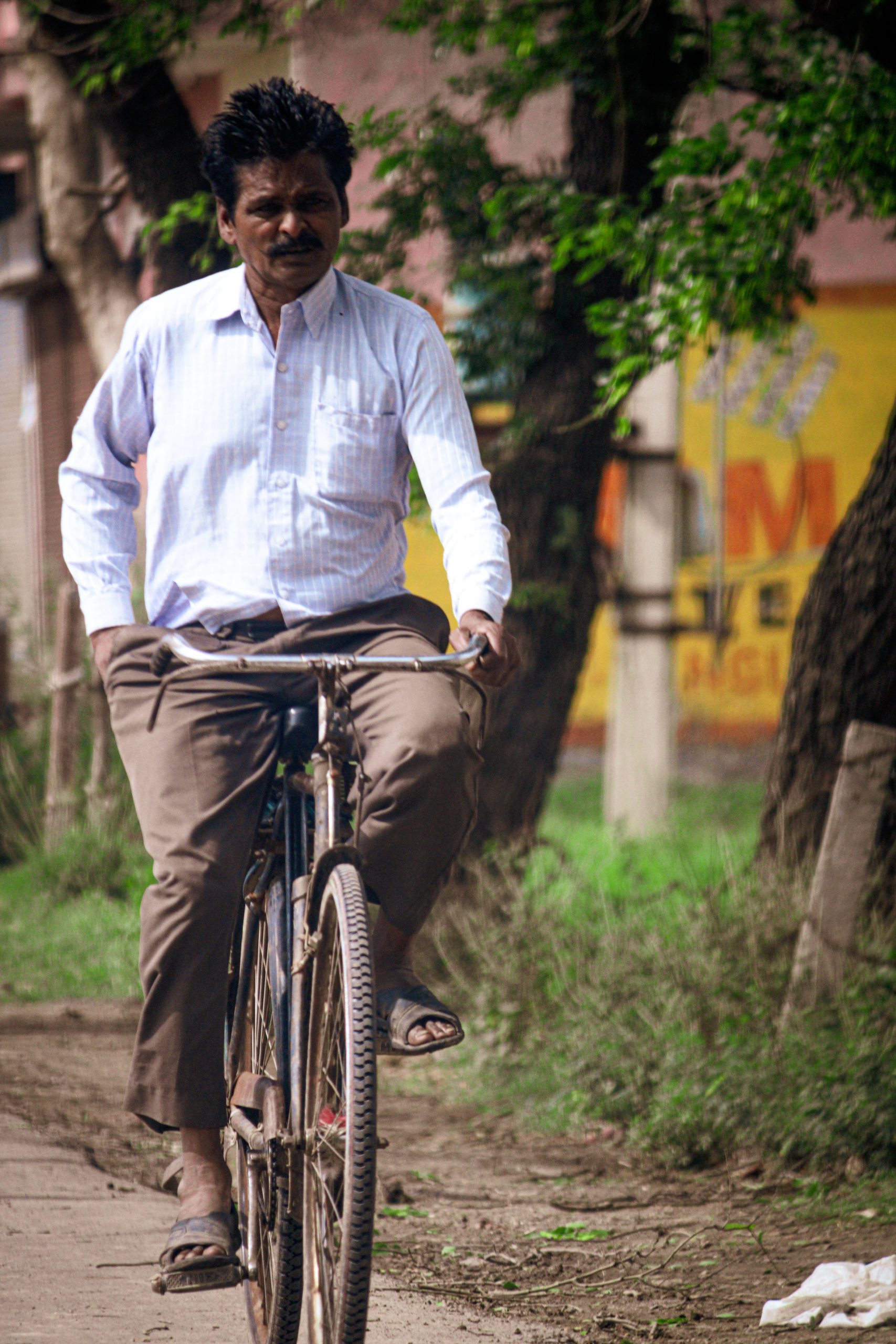 A man cycling in an Indian village