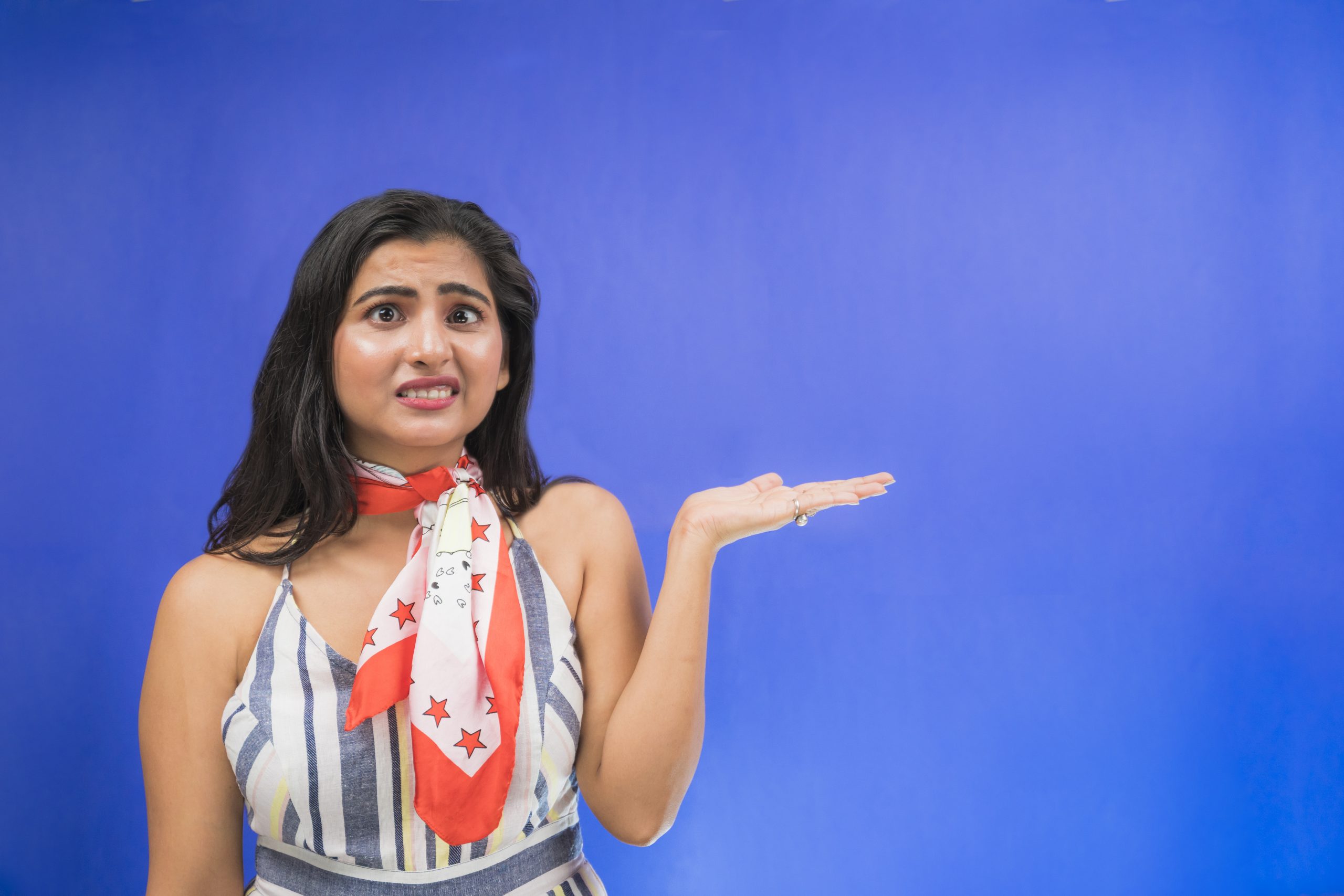 Unhappy Indian girl pointing hand sideways