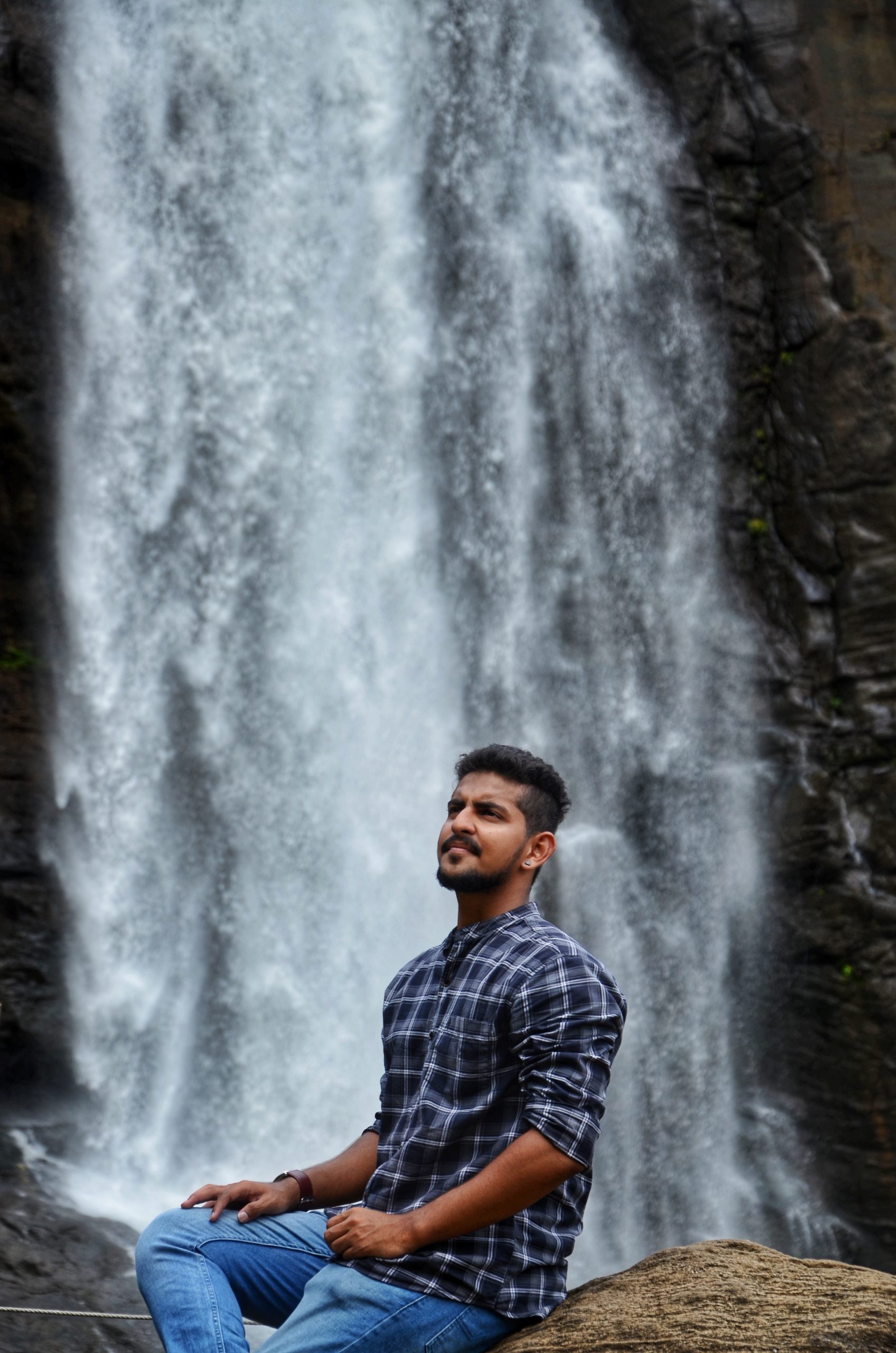 Man sitting by the waterfall