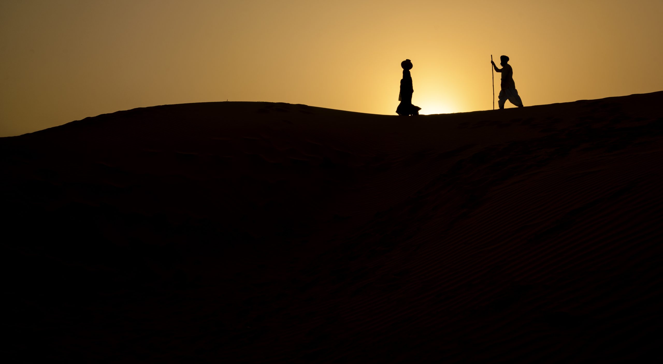 Two men walking in the desert.
