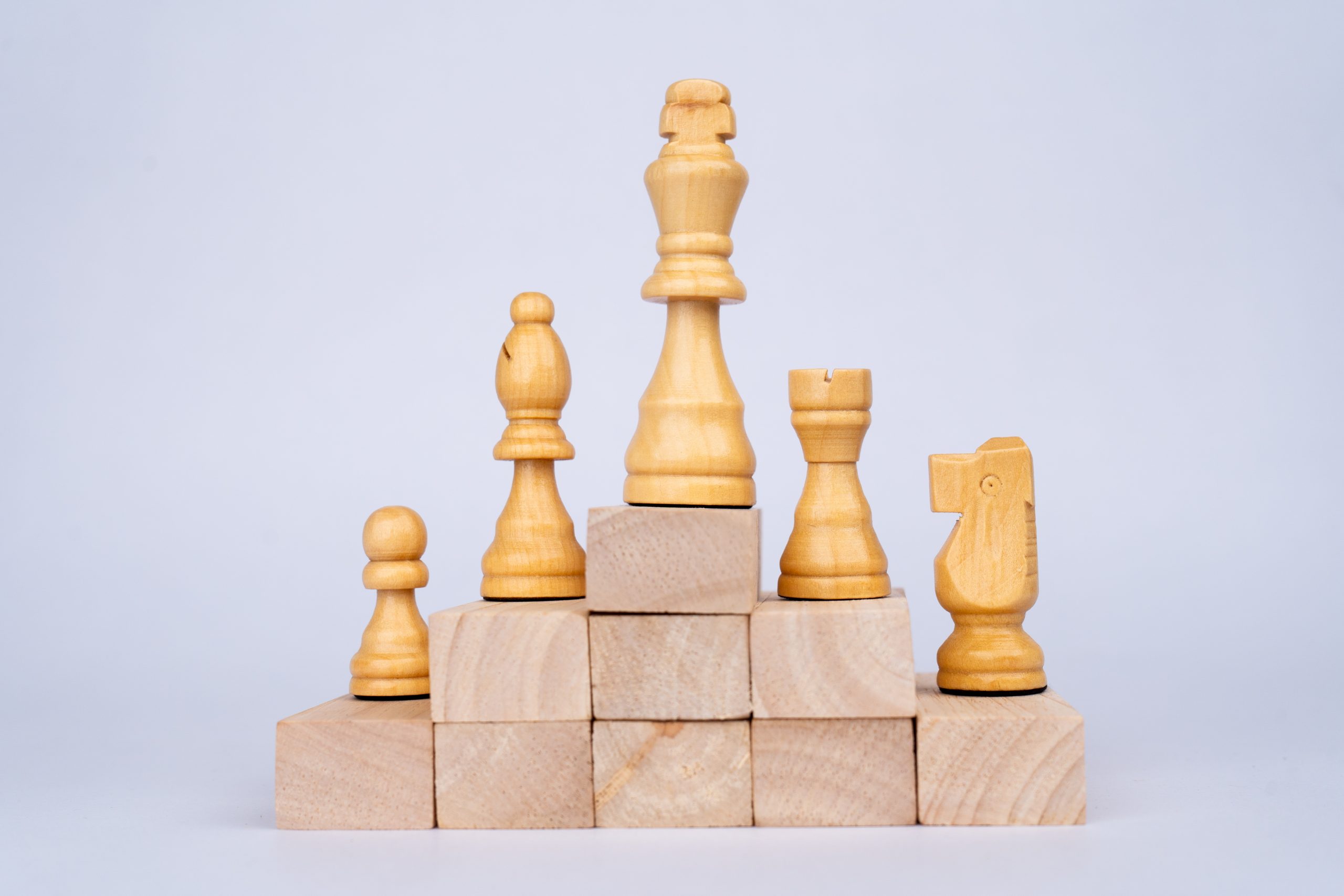 White chess pieces on wooden blocks