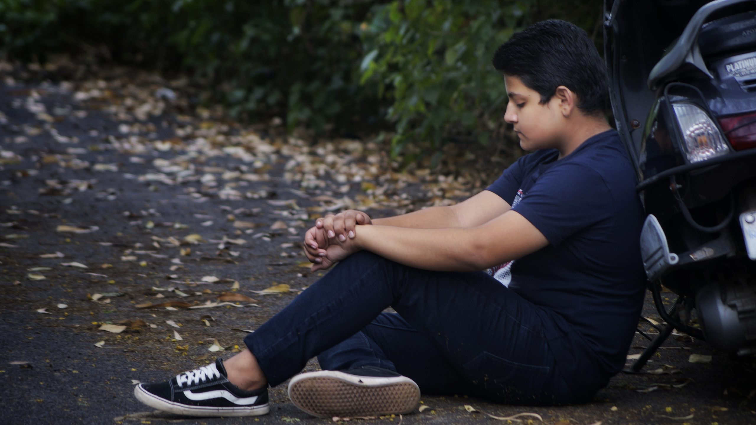 Young boy sitting alone with sad look