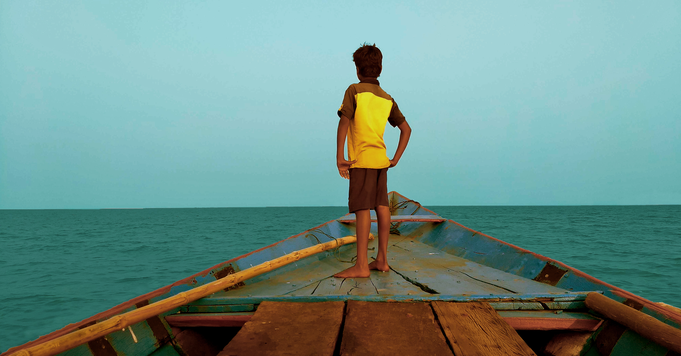 A boy standing on a boat