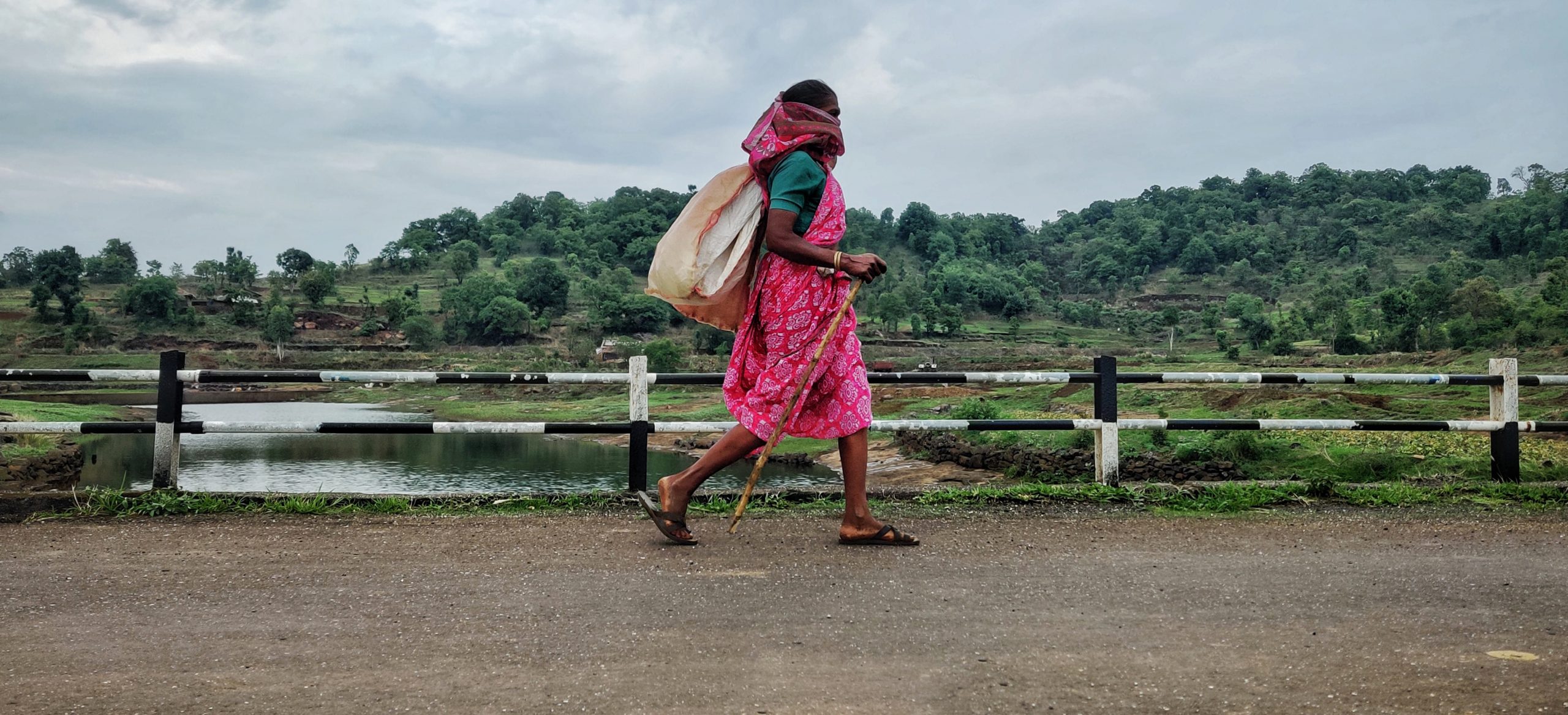 Woman walking on a road and watching the nature.