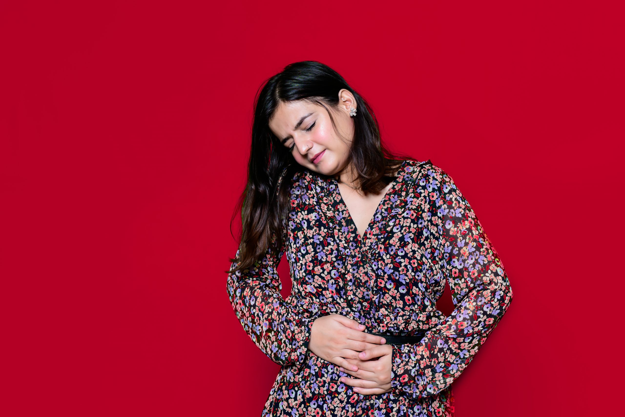 A Girl with Stomach Ache in Red Background