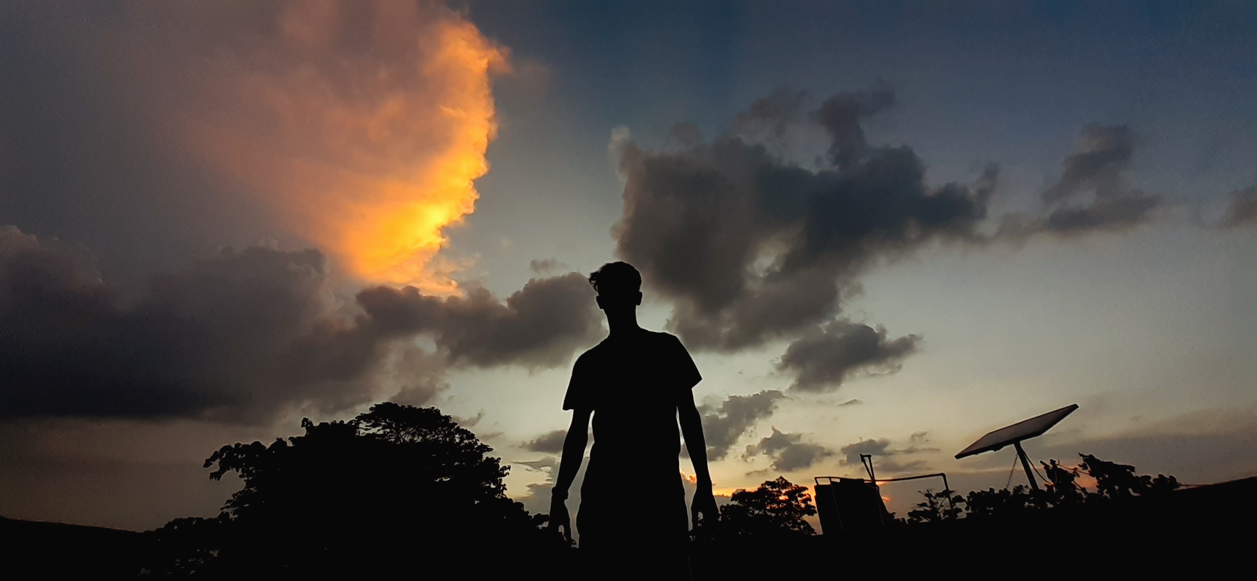 A boy enjoying sunset clouds