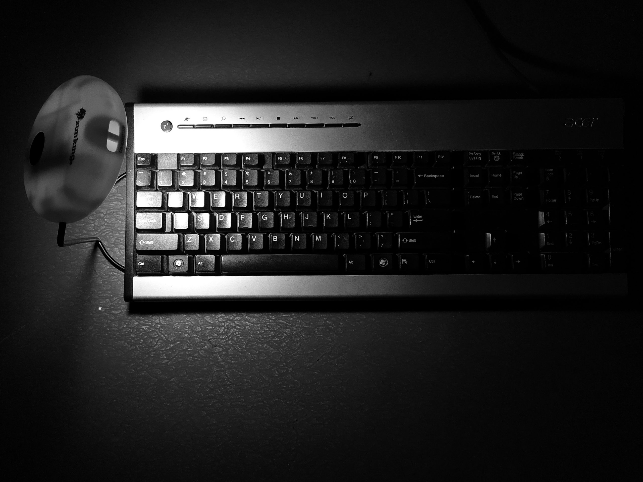 A computer keyboard and table lamp