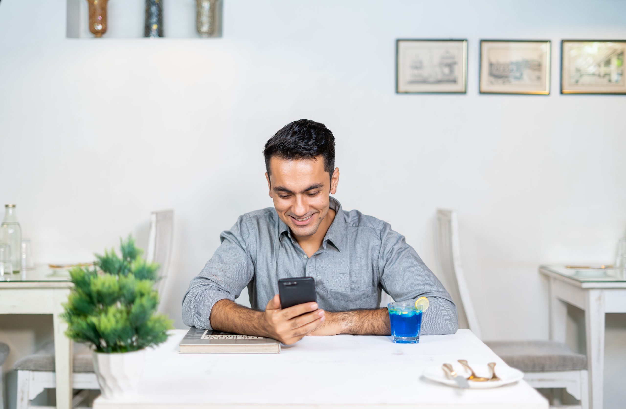 A happy person using phone in cafe