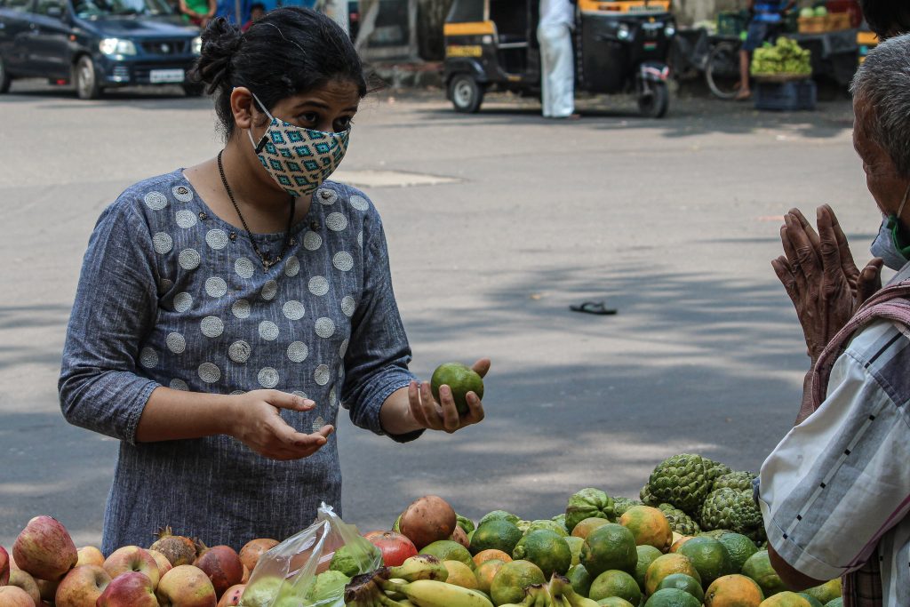 A lady bargaining with vendor PixaHive