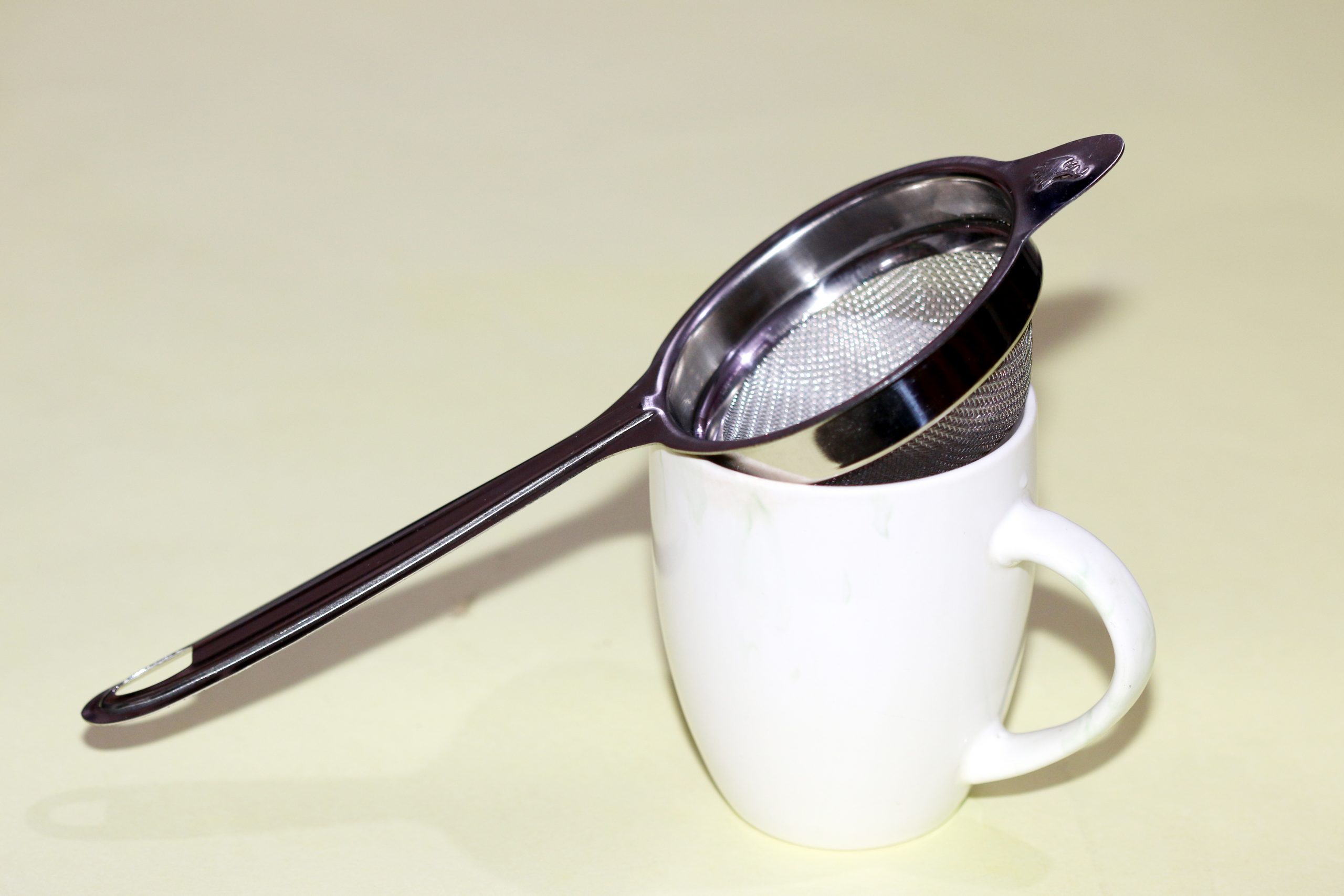 A tea strainer and cup