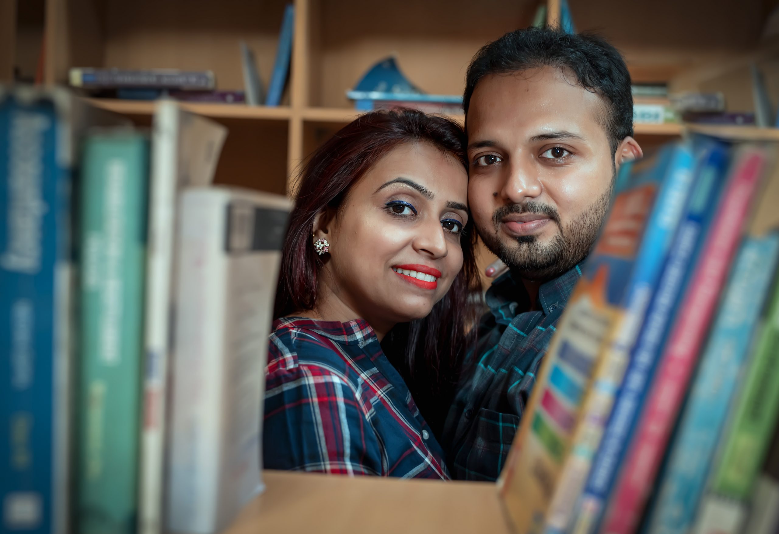 couple posing amidst books