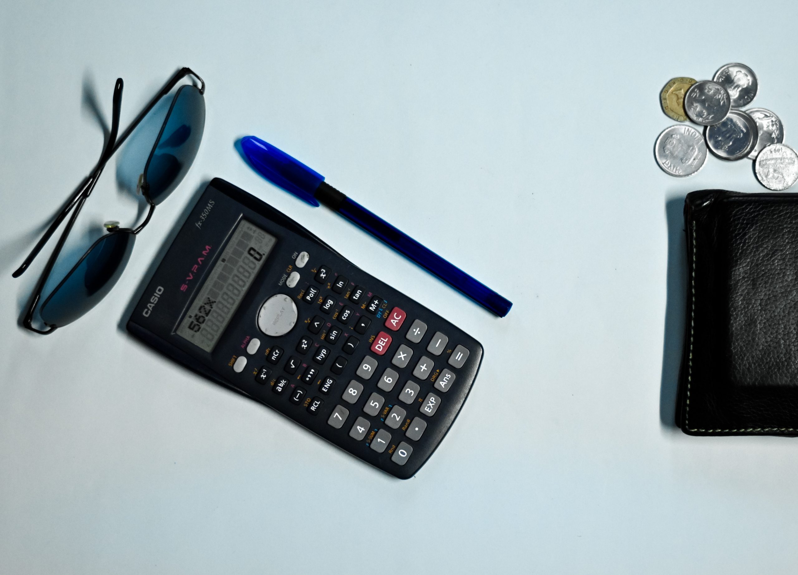 calculator, shades, pen, wallet and coins