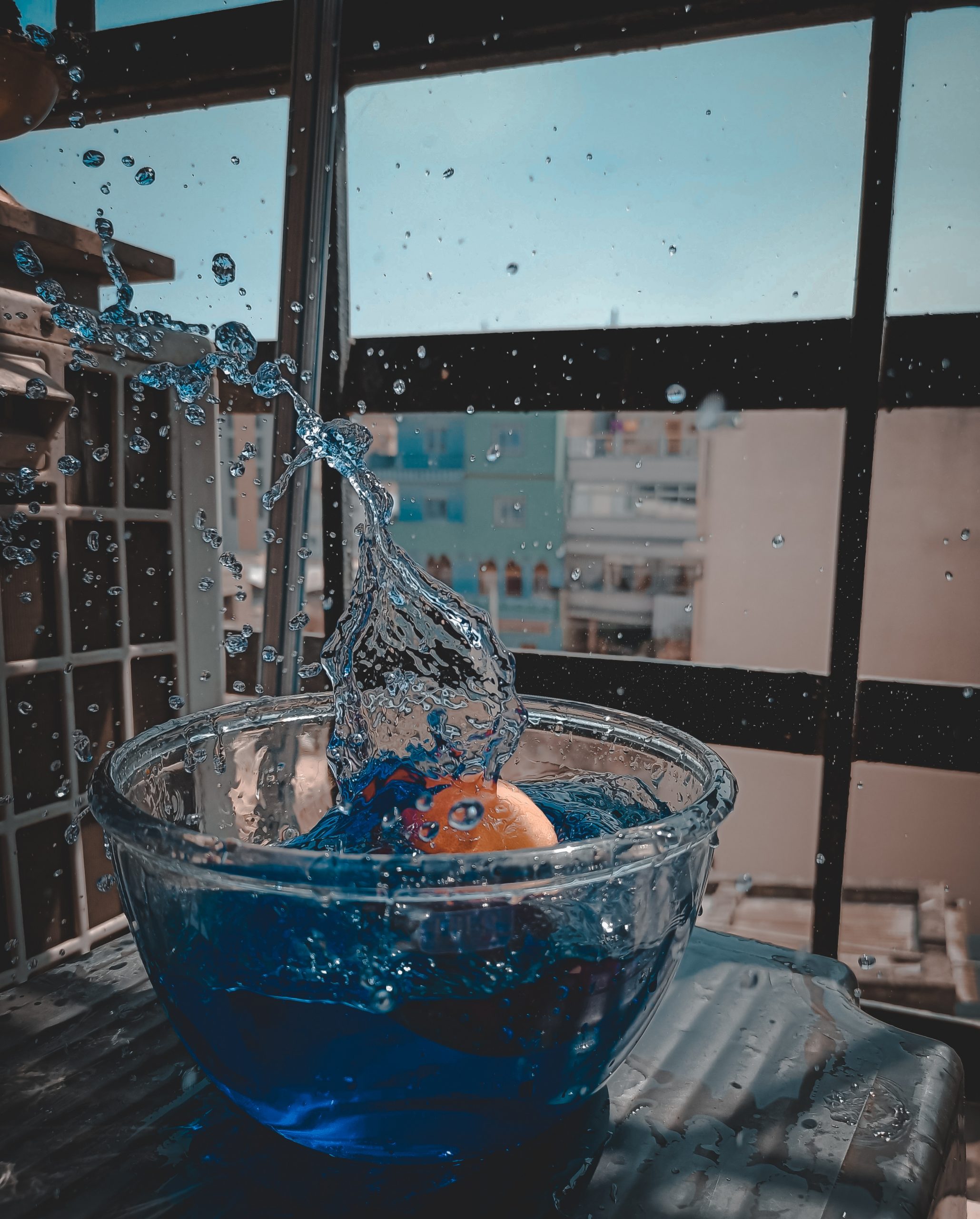 ball dropping in a bowl of blue colored water