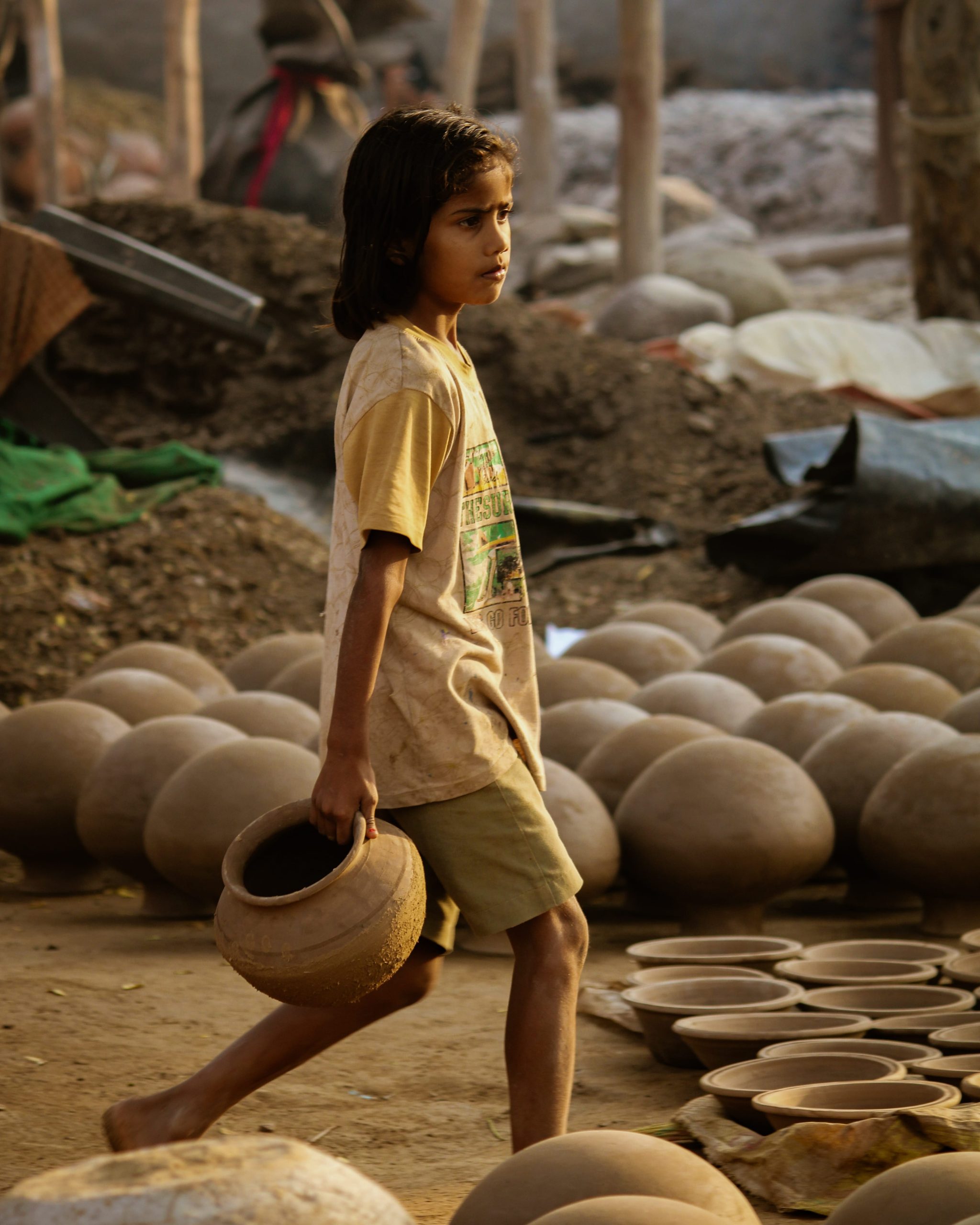 girl carrying clay pots