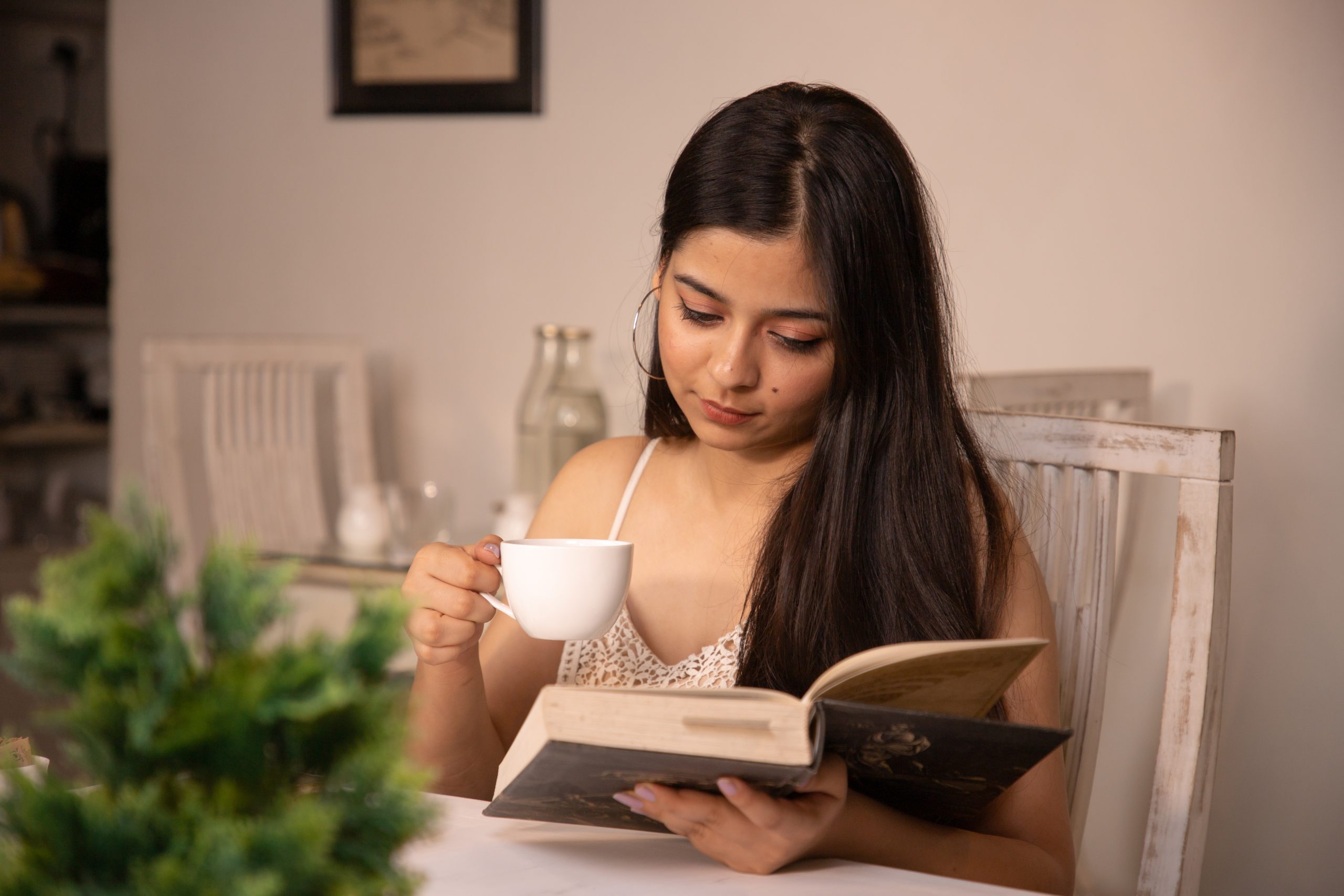 Girl reading book while having coffee