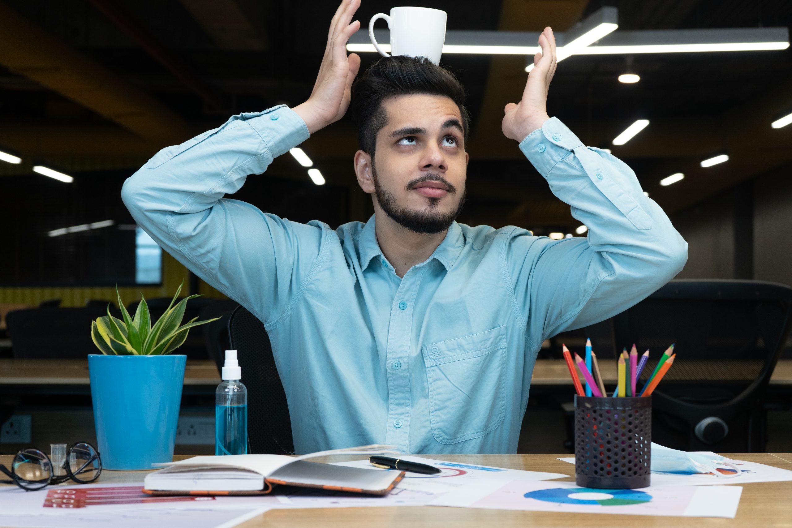 Man balancing coffee mug on head