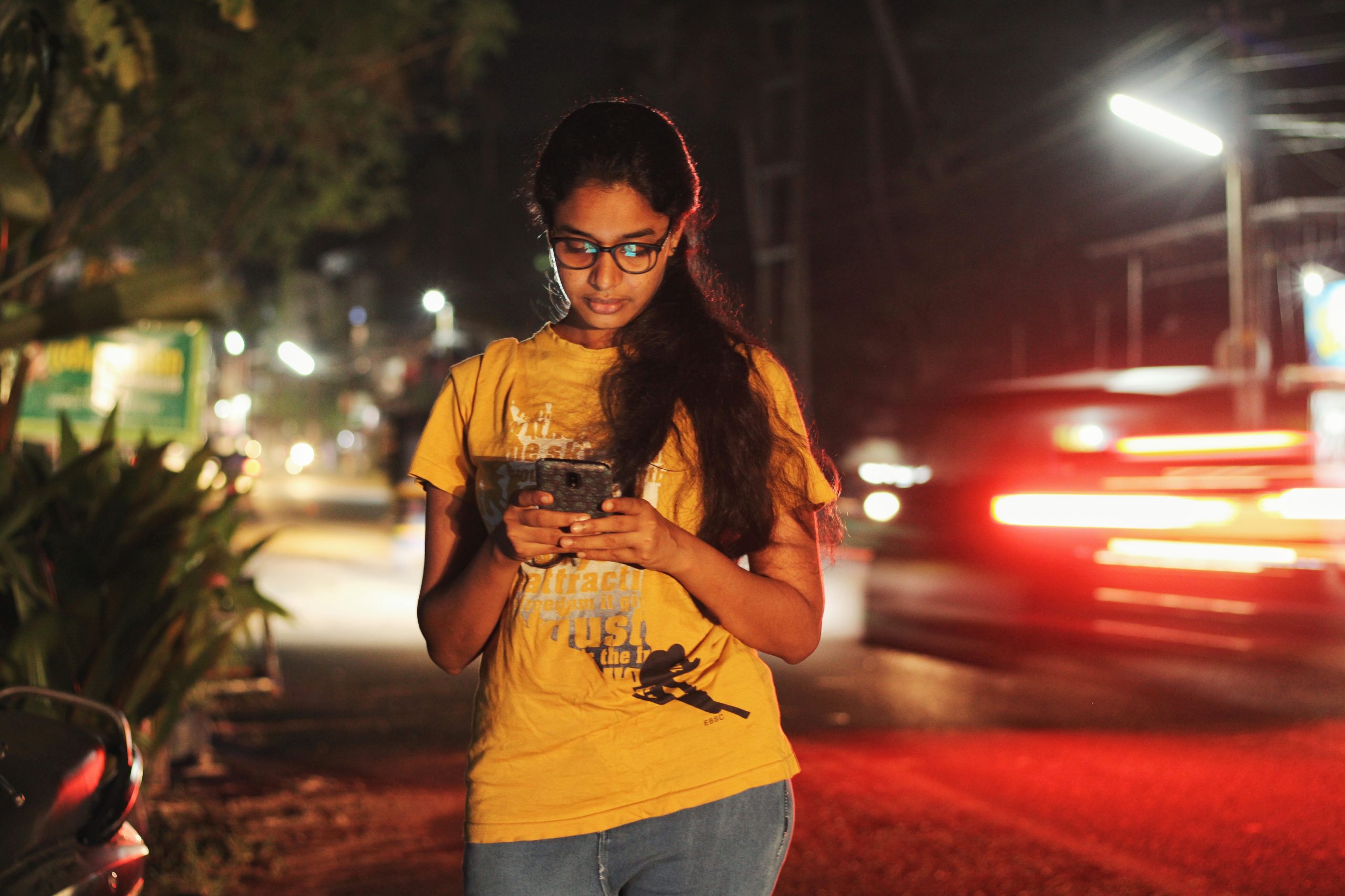 girl checking her phone on the roadside