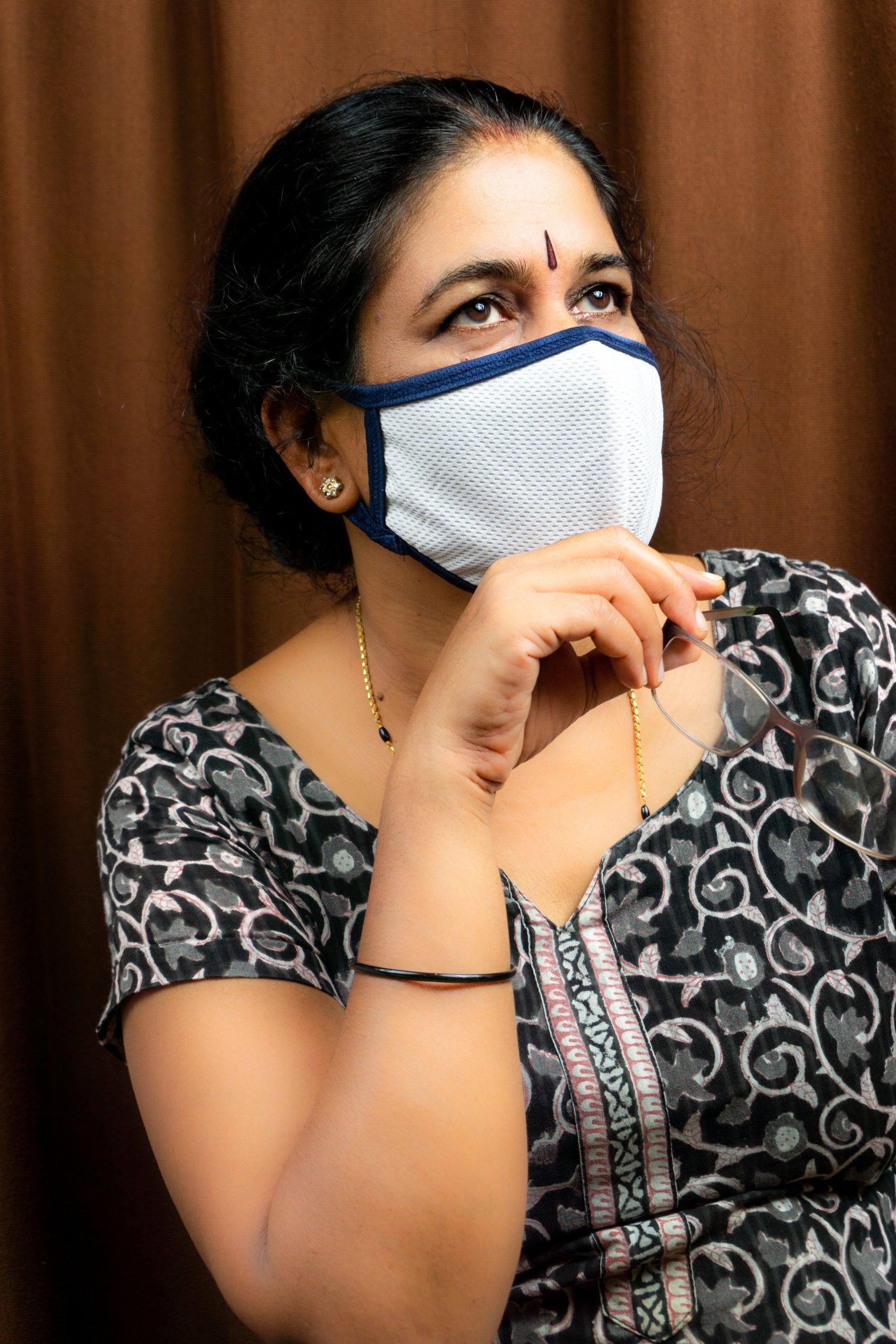 woman with mask holding spects