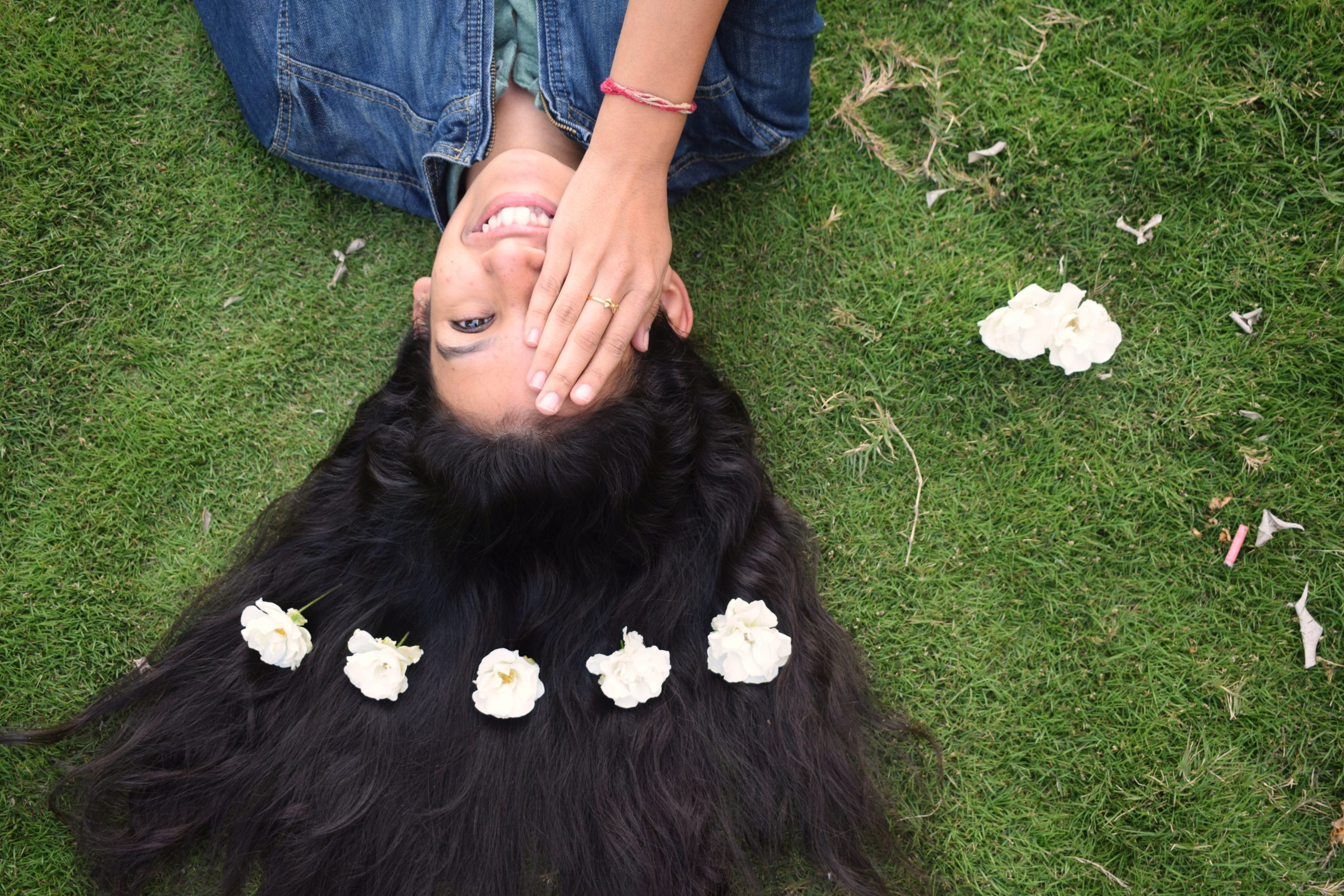 A girl laying with flowers on her hairs.