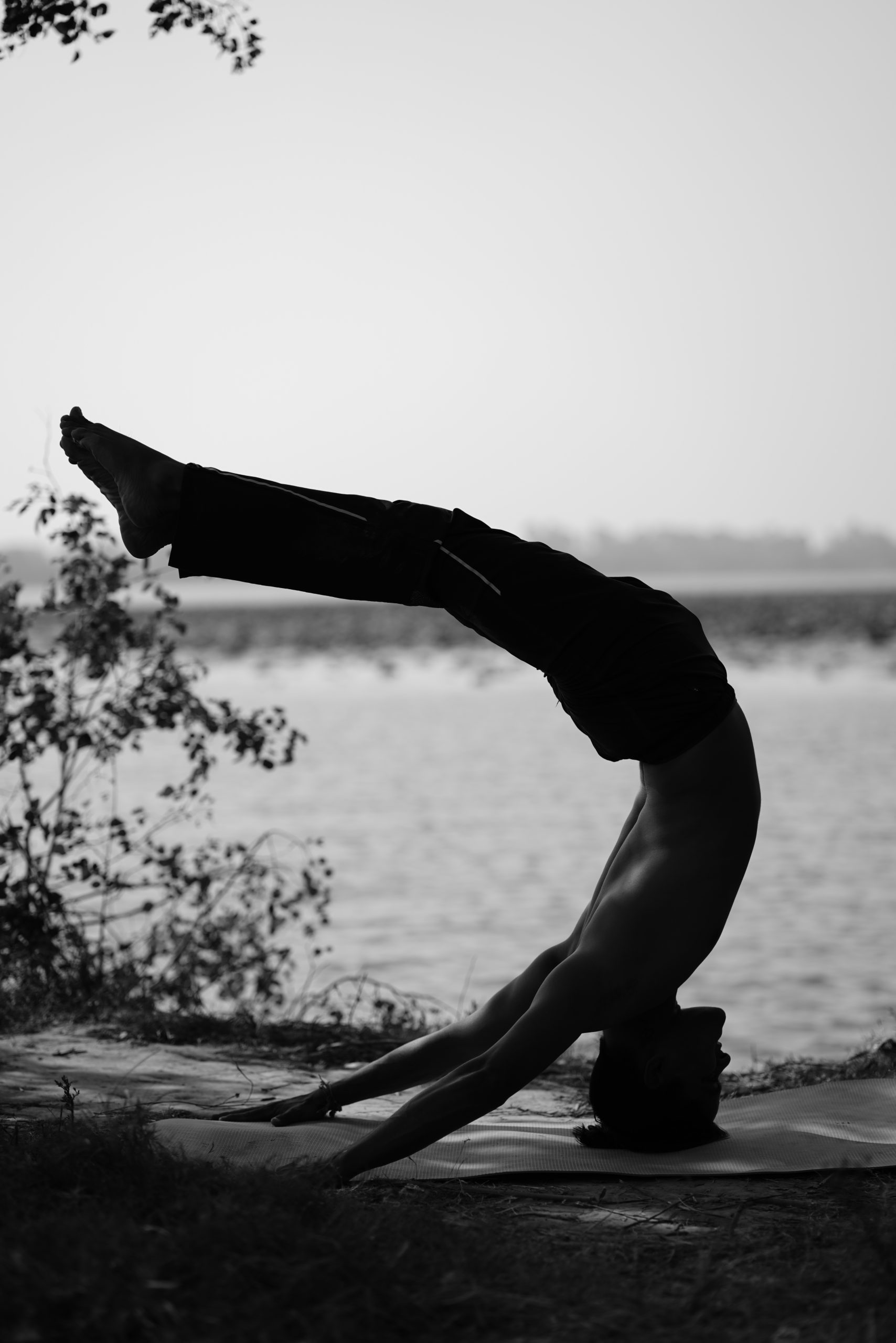 man doing yoga on lake side