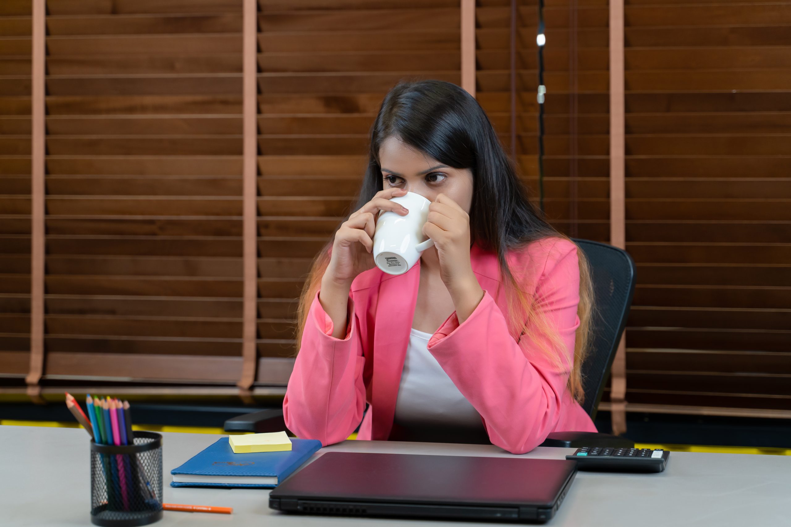 Tired businesswoman drinking coffee.