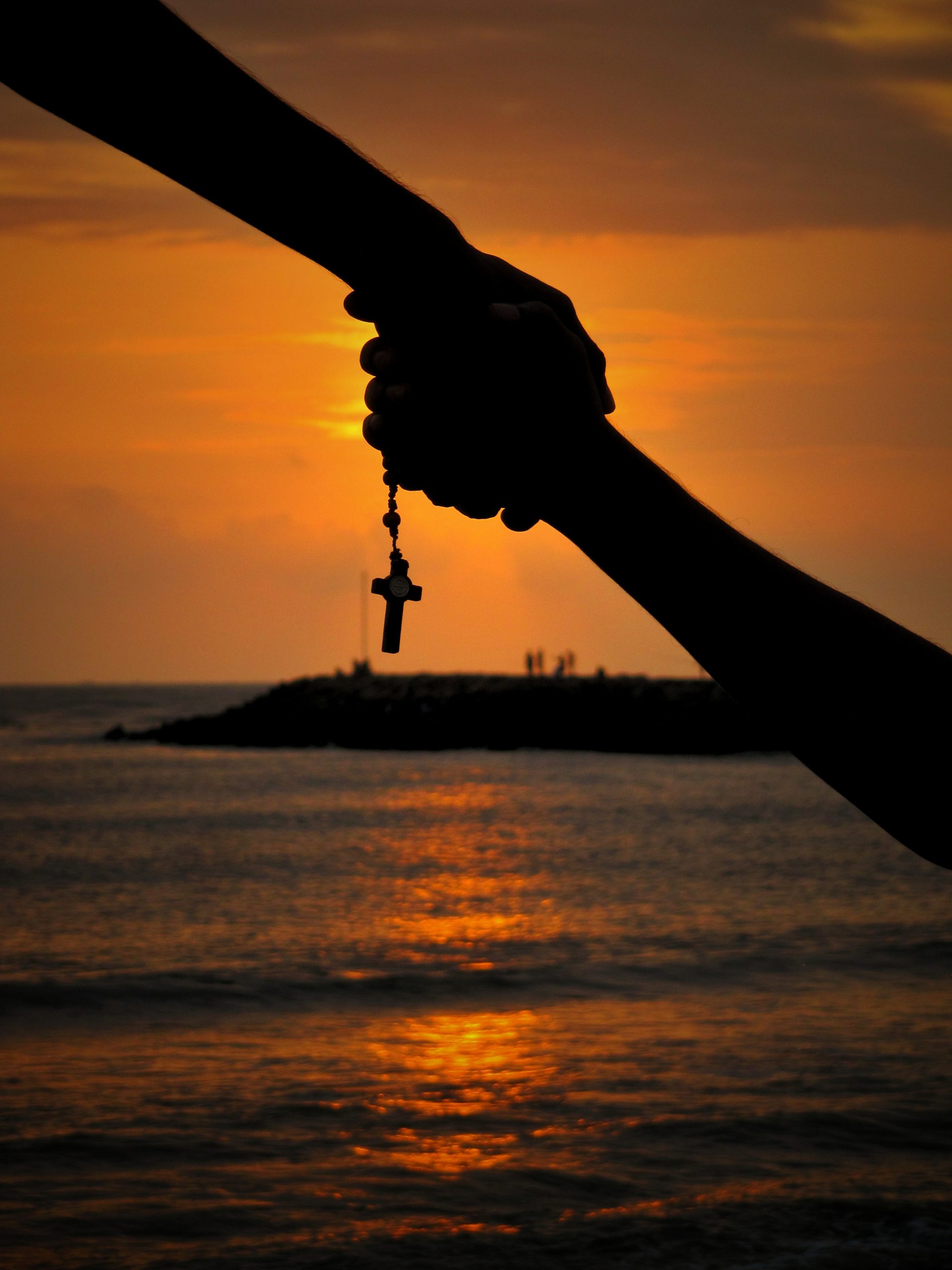 silhouette of holding hands at sunset