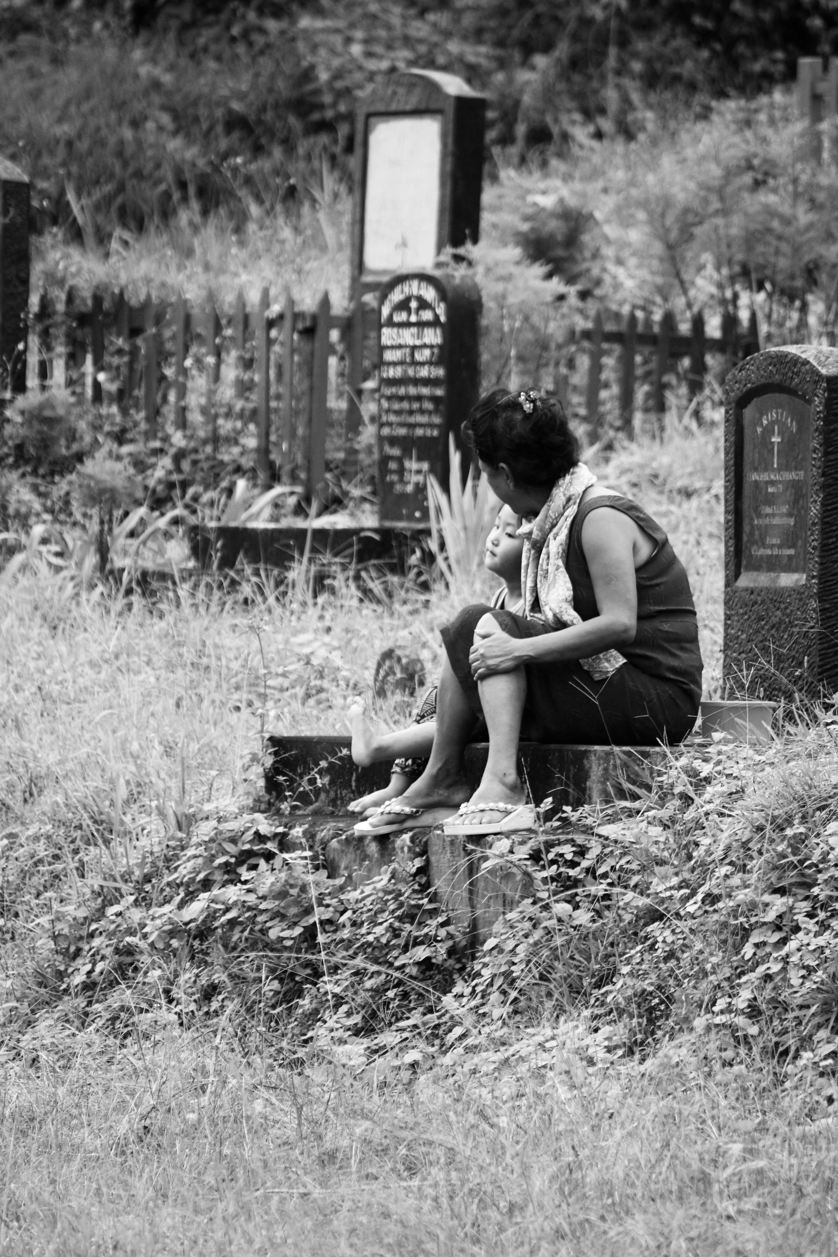 woman sitting near a grave