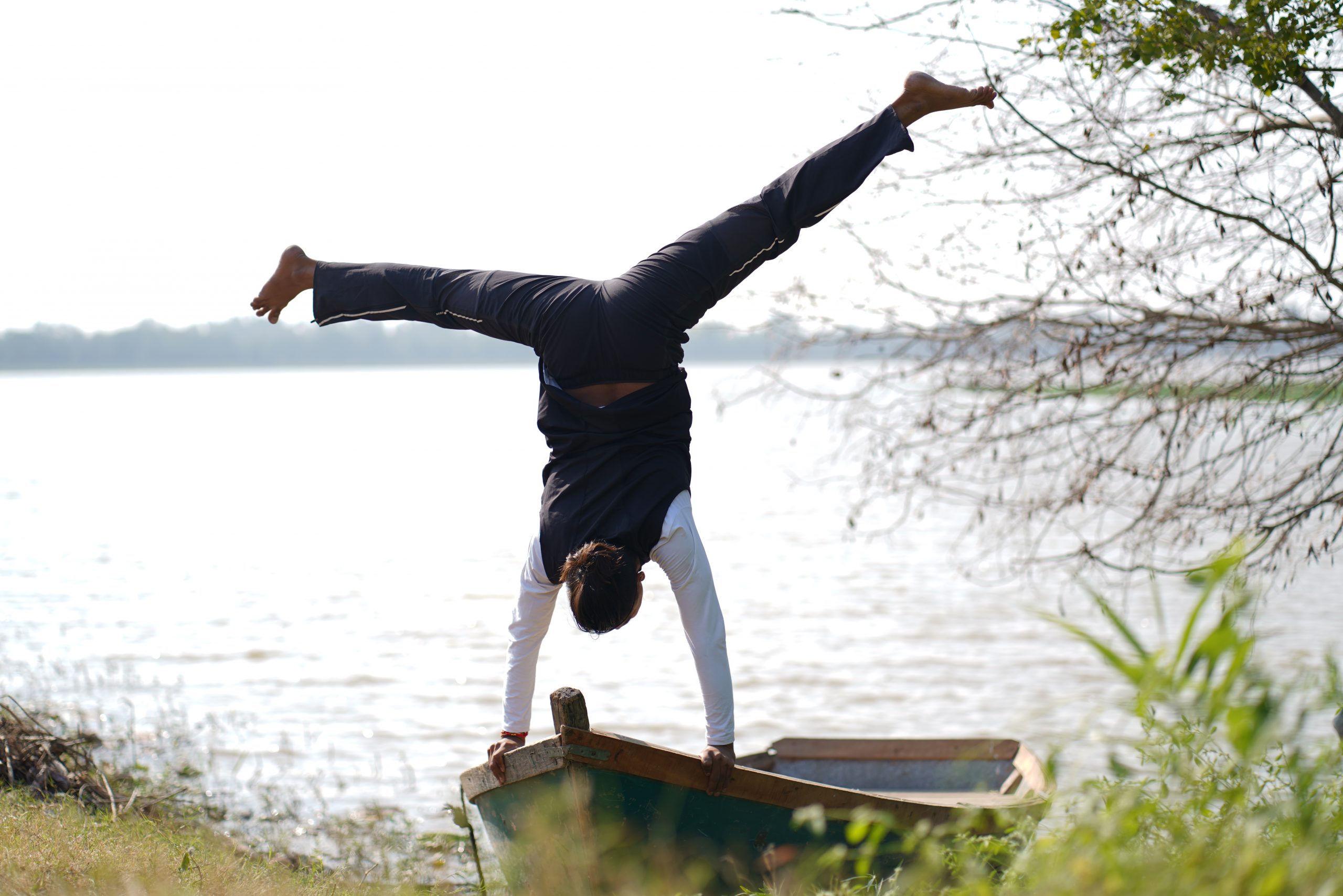 man doing yoga on lake side