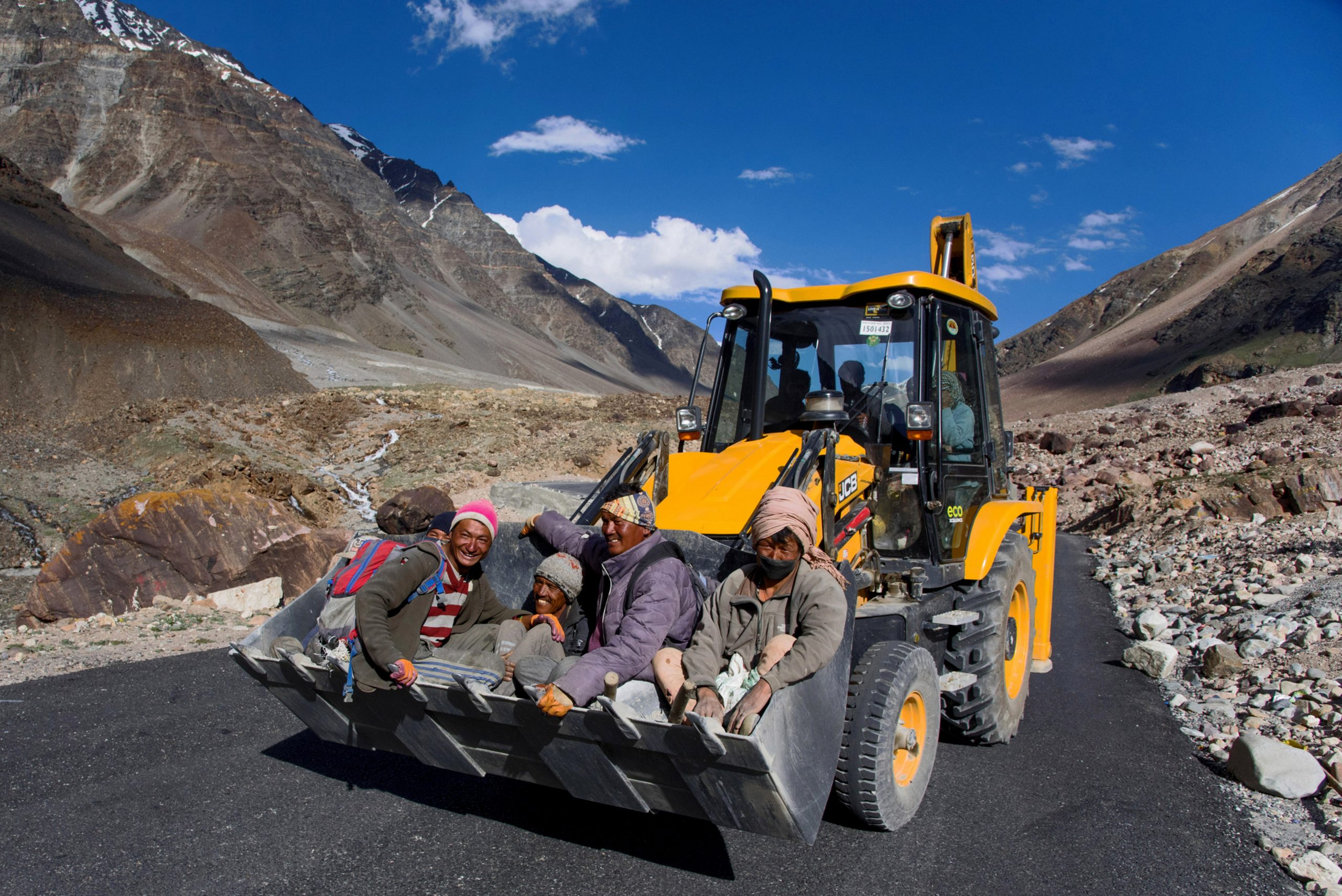 Workers riding on a JCB Excavators